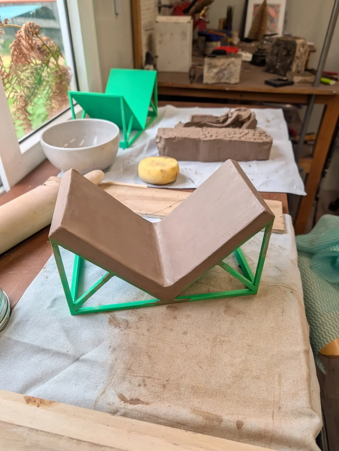 WORK IN PROGRESS - my idea for making ceramic book ends look like it might work. I had my husband 3D print a support frame to hold the right angle ceramic slabs in place whilst they dry to leather hard. 

Ideally they will just pop off the frames and