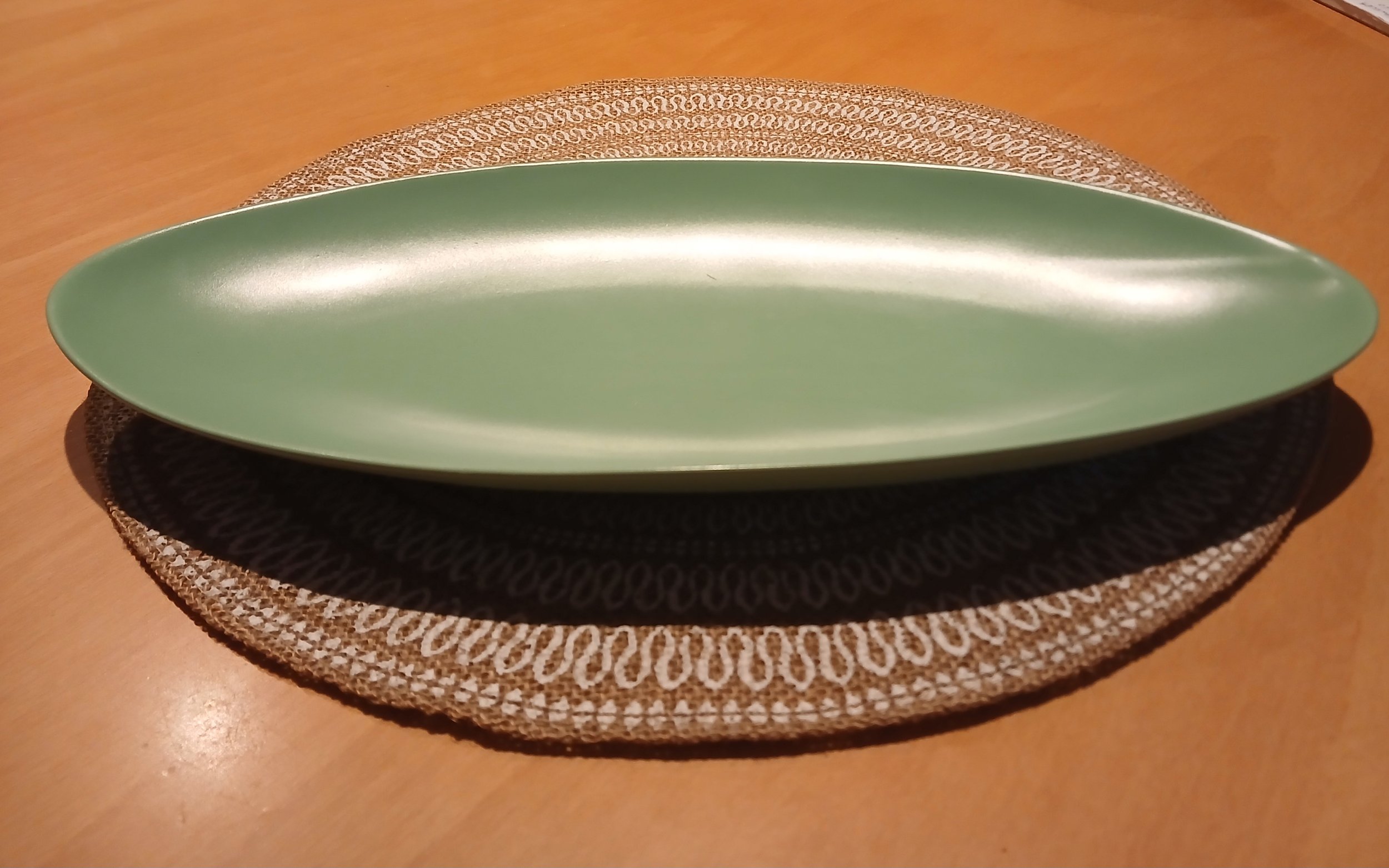 Green ceramic styling tray on woven neutral mat
