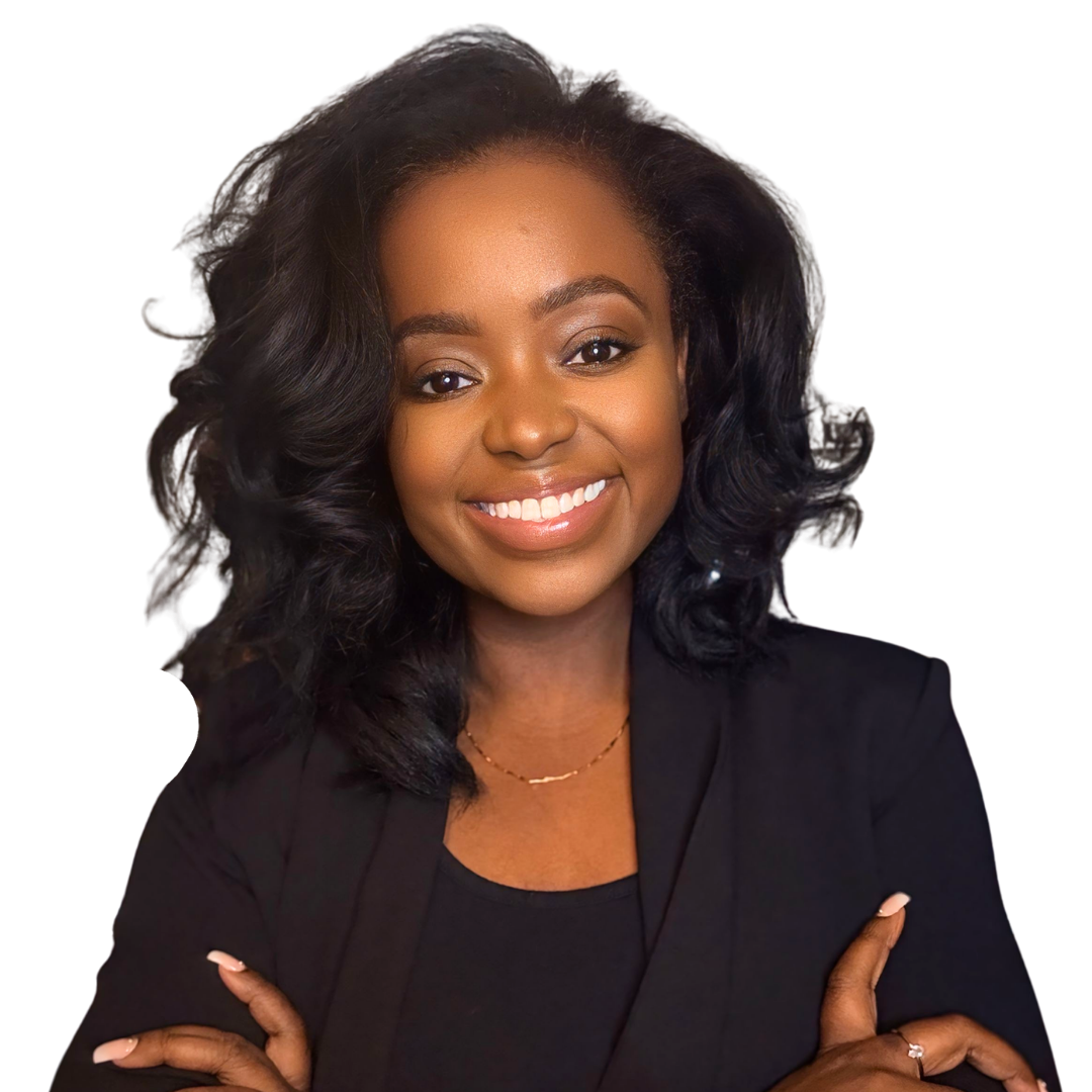 Smiling African American woman with wavy black hair, wearing a black blazer and gold necklace, with arms crossed against a black background.