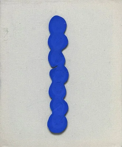 Six blue game pieces arranged vertically on a white surface.