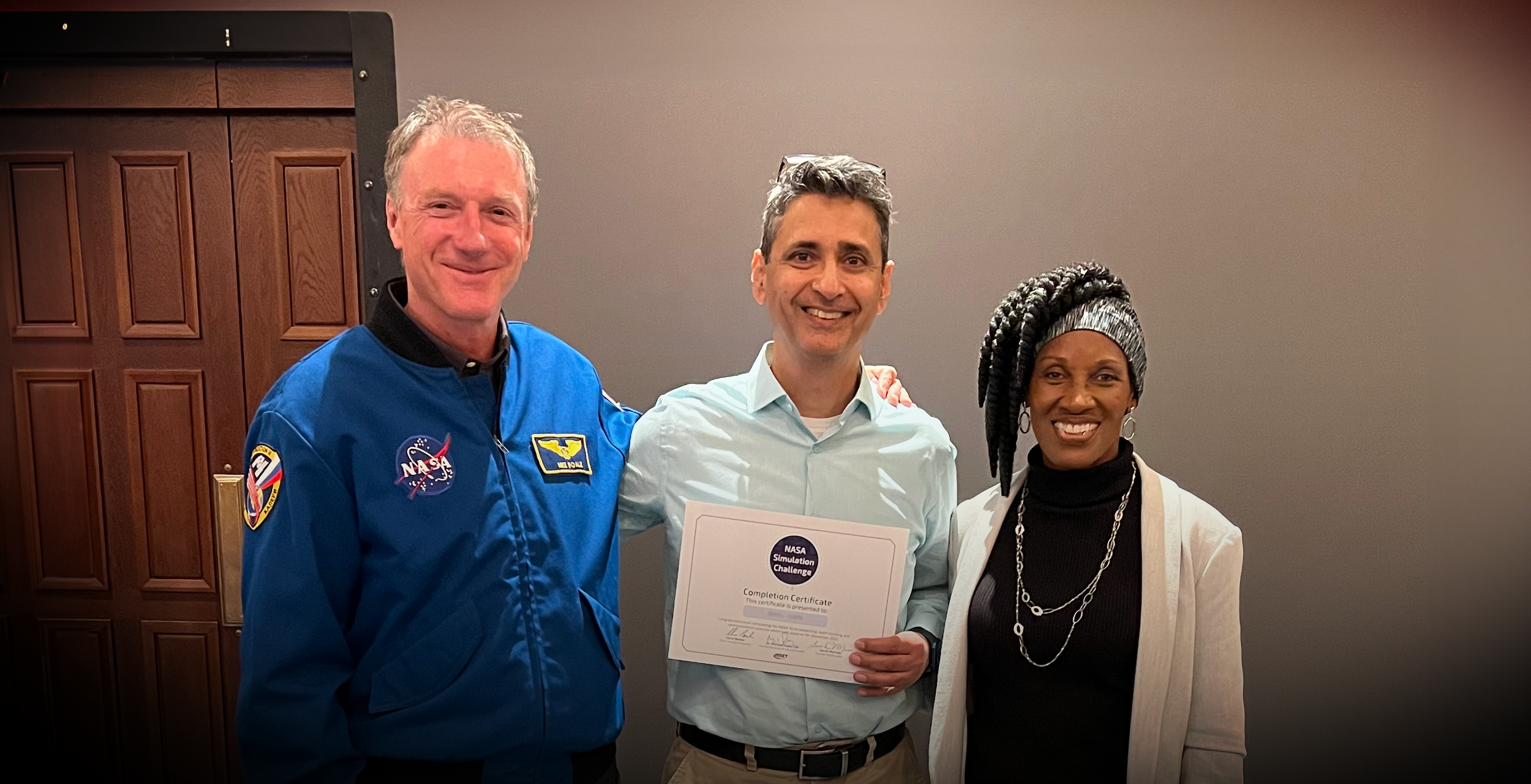 Astronaut Michael Foale and NASA leader Sarah Murray delivering leadership training to a corporate participant during an Astronaut Leadership development programme.