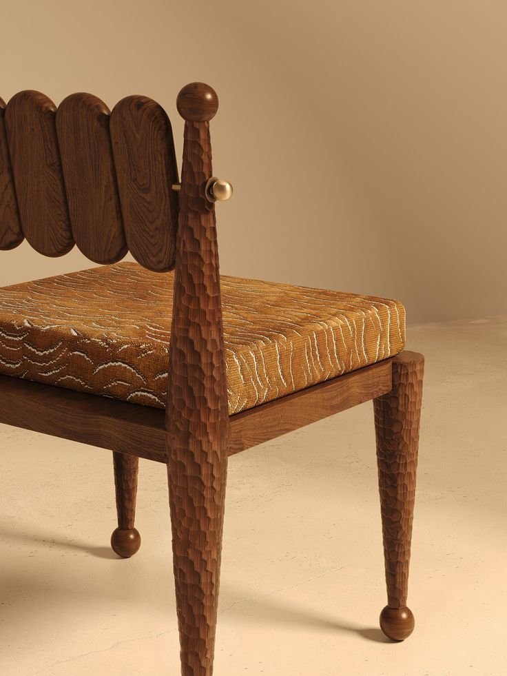 Close-up of a wooden chair with textured, hammered legs and a cushioned seat with patterned upholstery.
