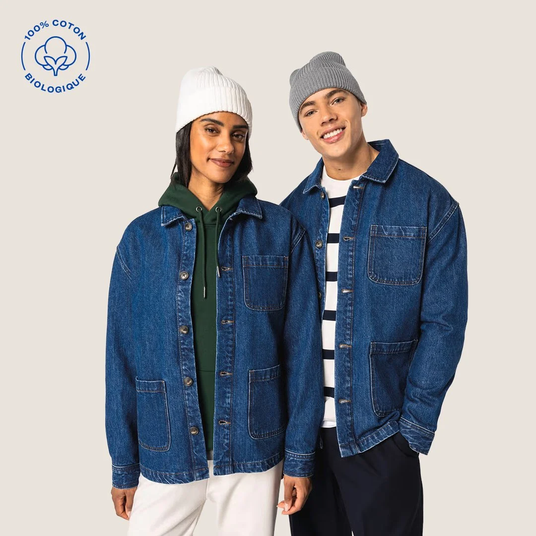 Deux jeunes modèles portent des vestes en denim, l'un en sweat à capuche vert et le autre en t-shirt rayé, avec des bonnets gris et blanc, contre un fond clair, avec un logo biologique en coton.