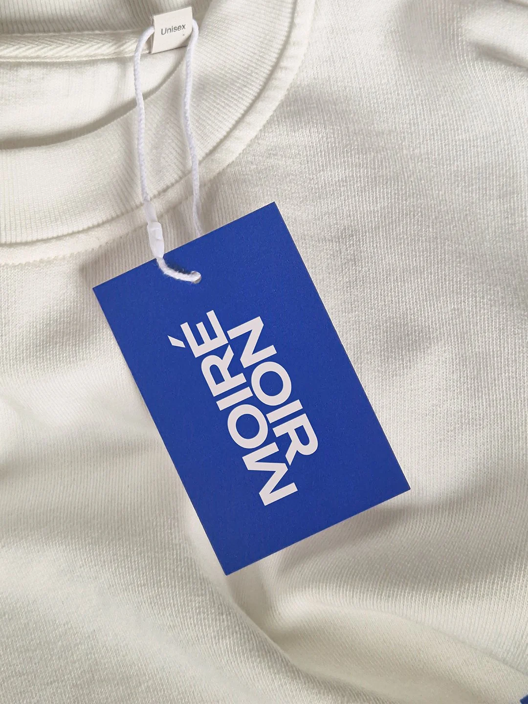 Vêtements blancs avec une étiquette de marque "The North Face" attachée à la couture.