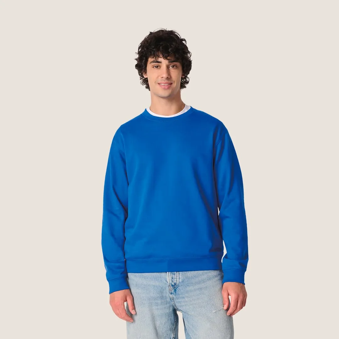 Jeune homme portant un sweat bleu clair avec un fond beige