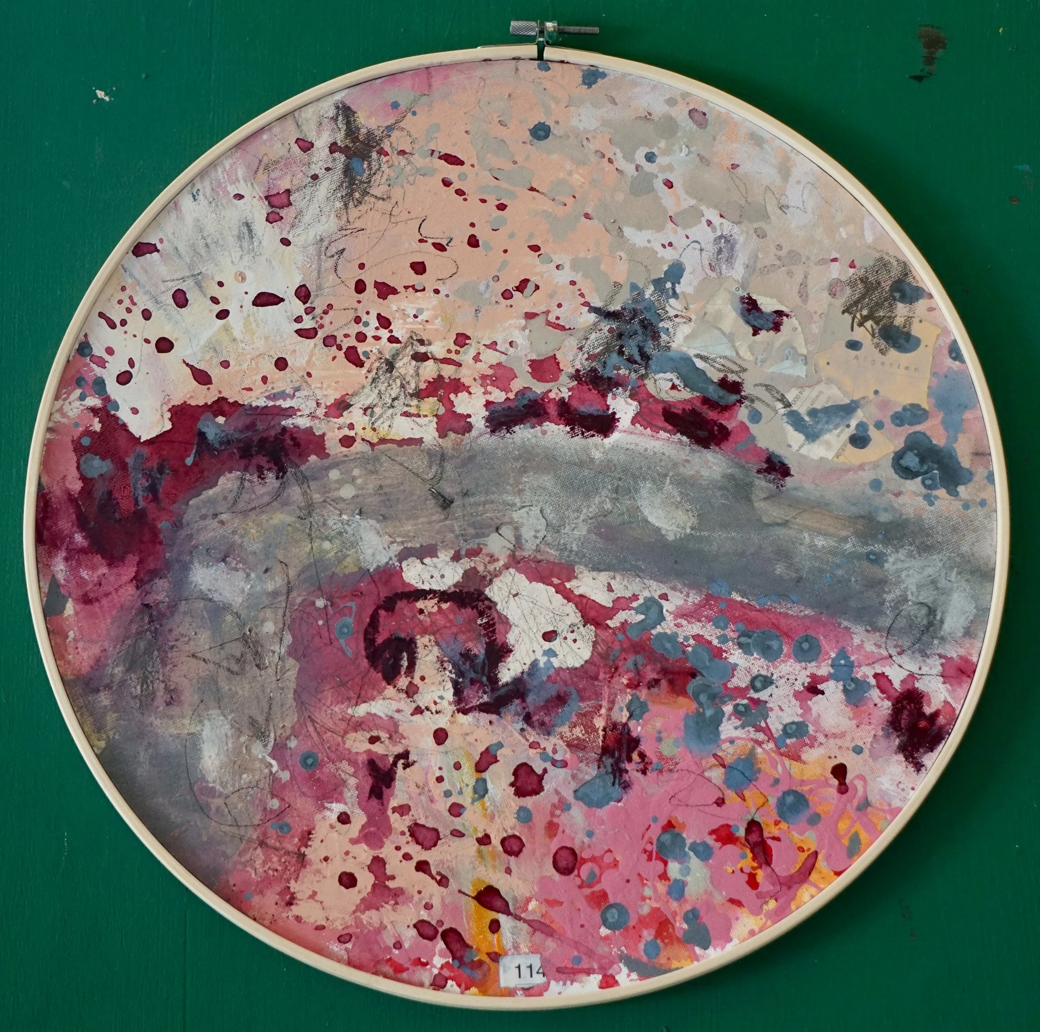 Abstraktes Gemälde mit bunten Spritzern und Pinselstrichen, hauptsächlich in Rosa, Grau, Schwarz und Blau, in einem runden Rahmen