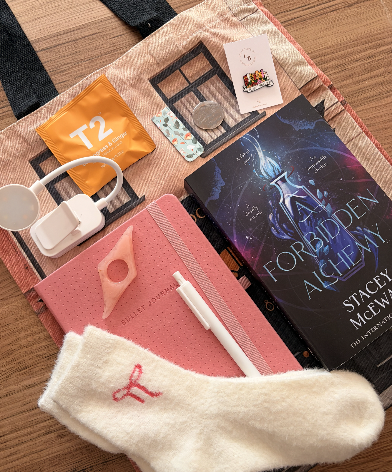 top view of notebook, book, pen, tea and book light