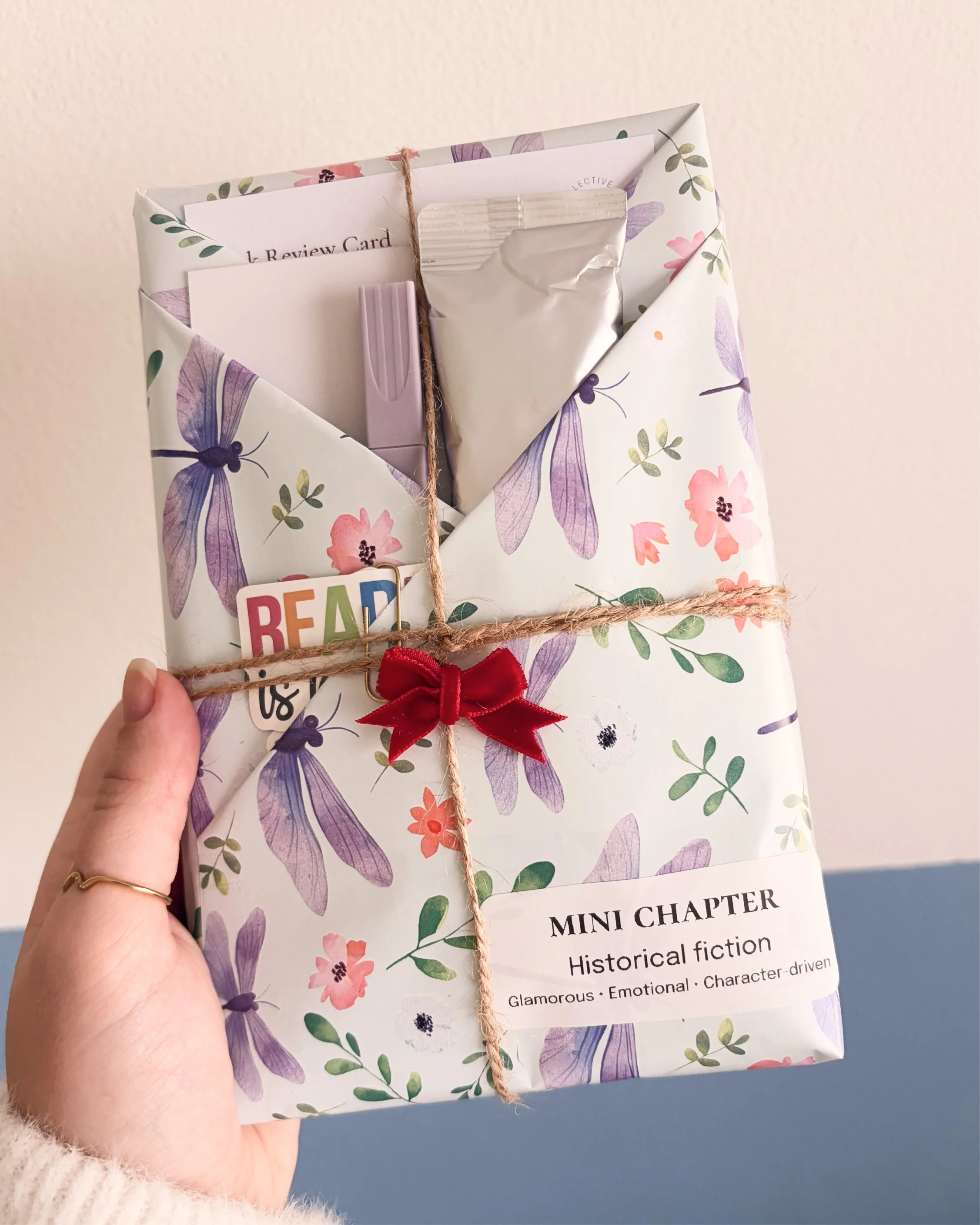Hand holding smaller wrapped book against wall.jpg