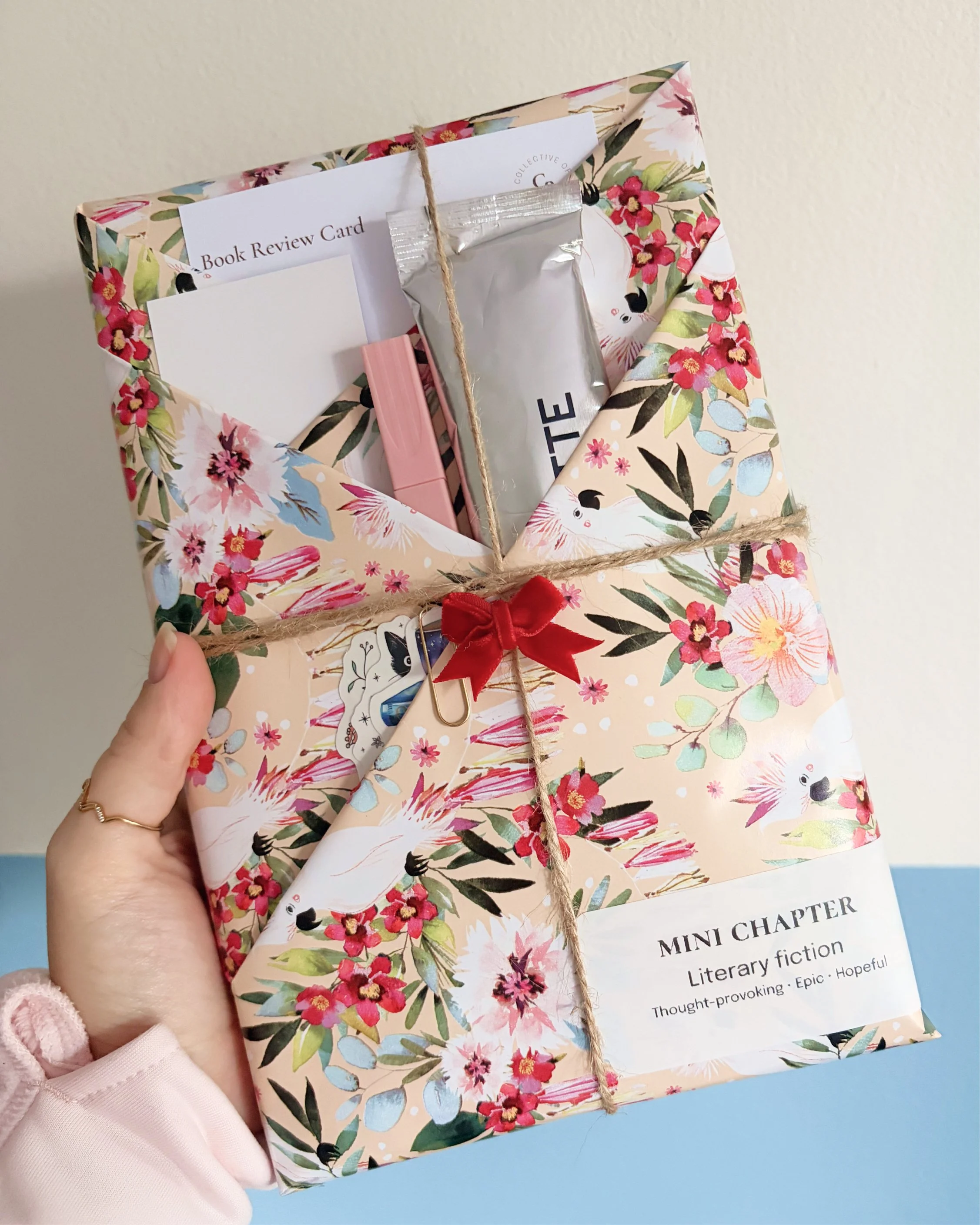 Hand holding wrapped book against wall.jpg