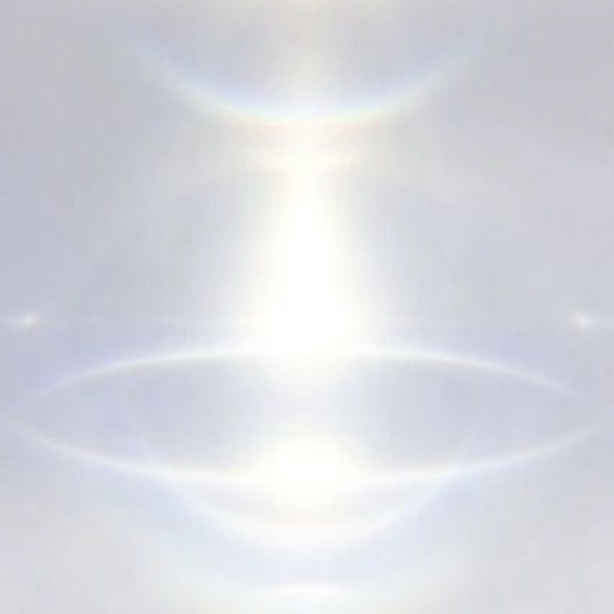 Heller Himmel mit Sonnenhalo und Regenbogenreflexion