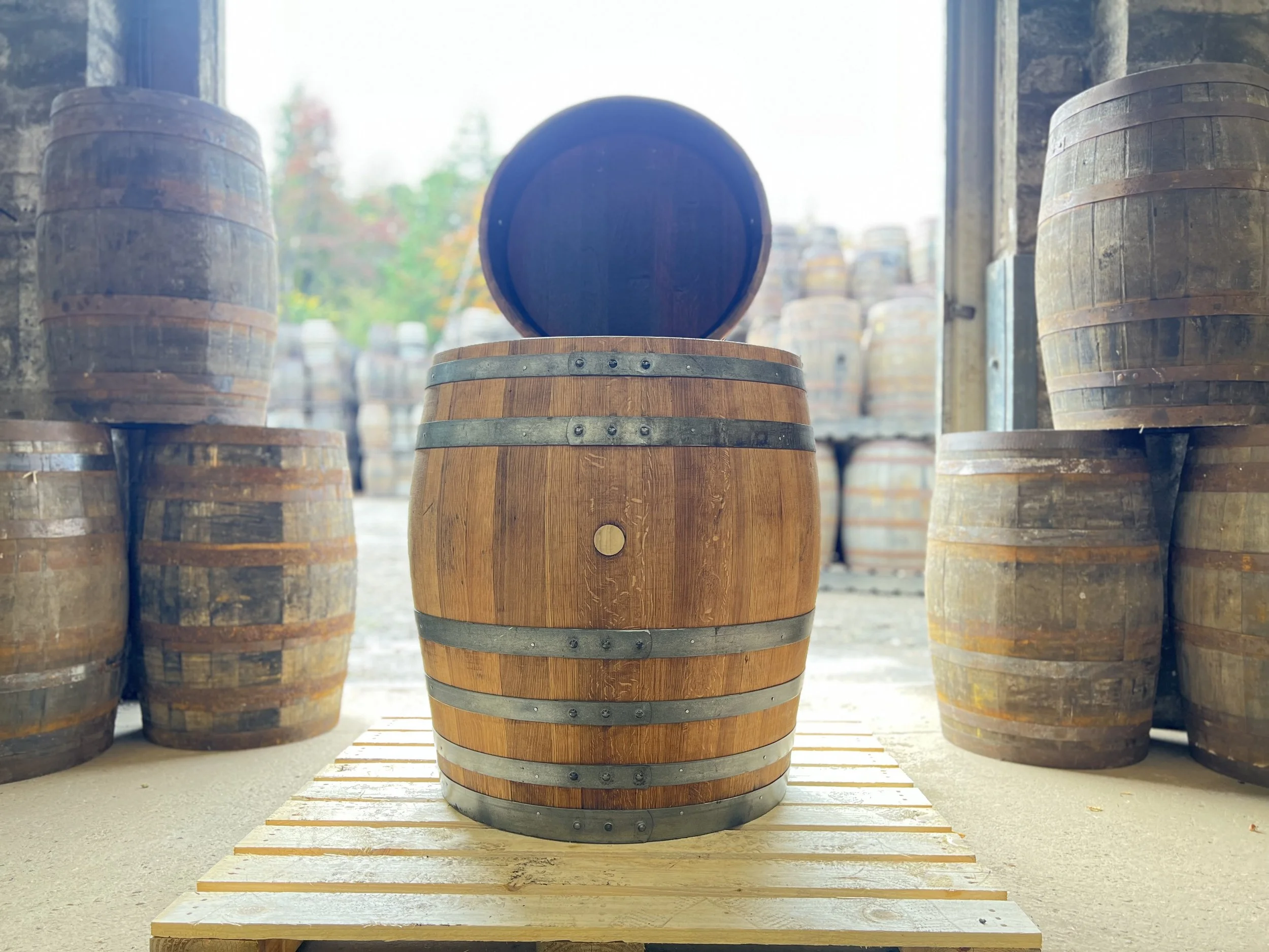 Two wooden barrels, one rustic and one sanded.