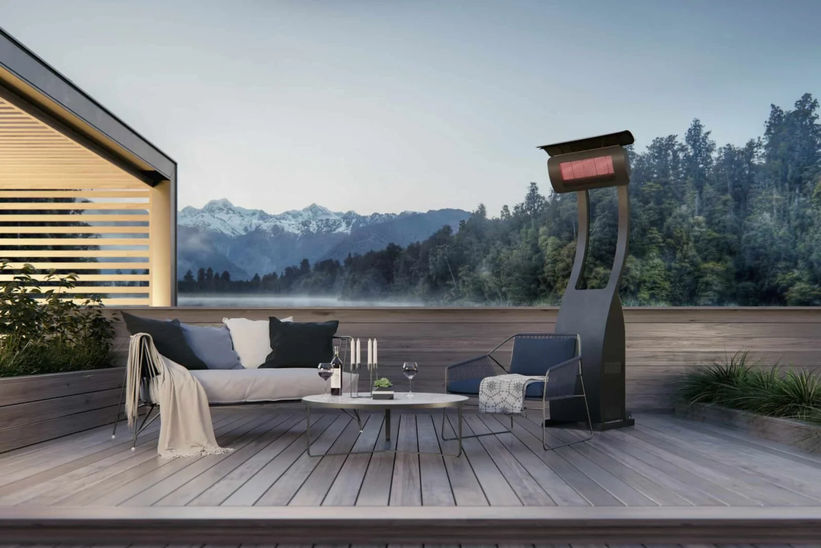 Outdoor patio with a sofa, chair, table, and heater, overlooking mountains and trees in the distance.