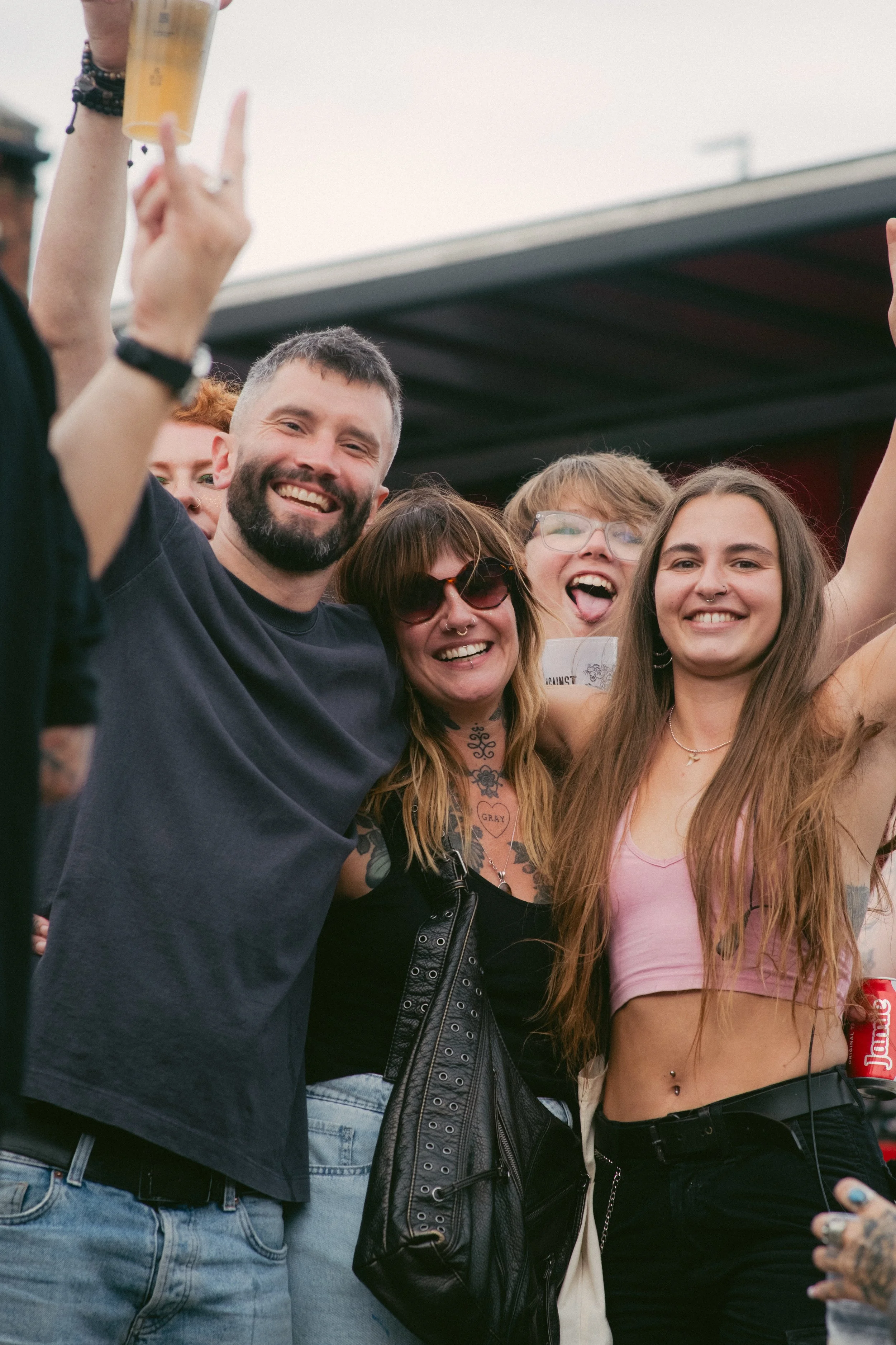 Group of smiling young adults at a social outdoor event, celebrating and enjoying themselves.