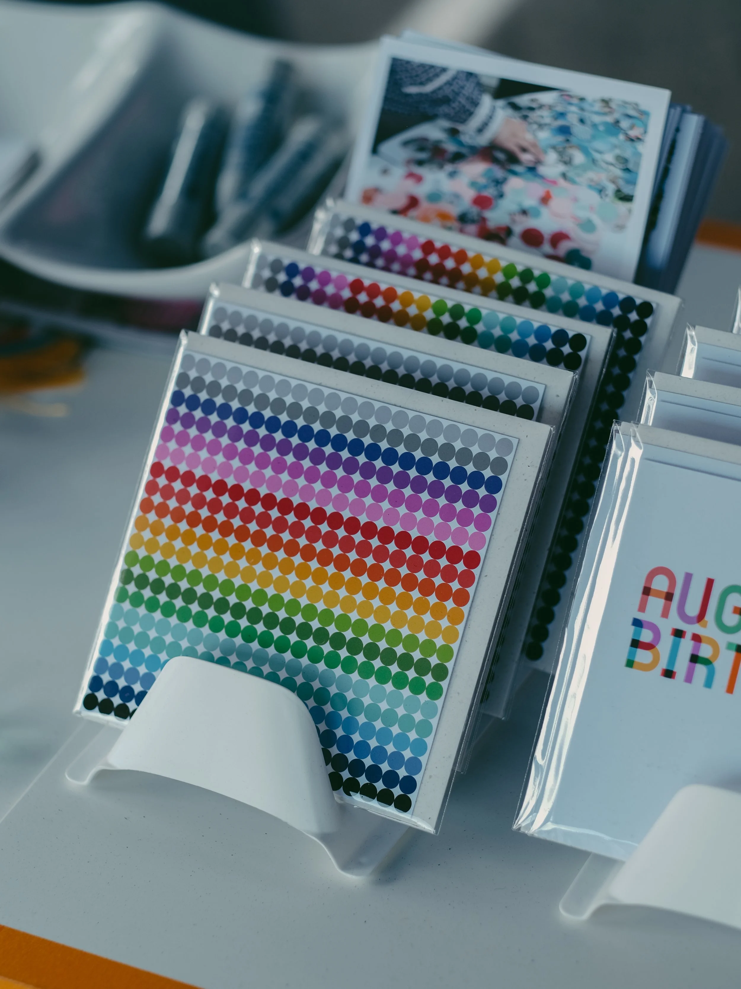 Color swatch books with various shades arranged in rows on display stand.