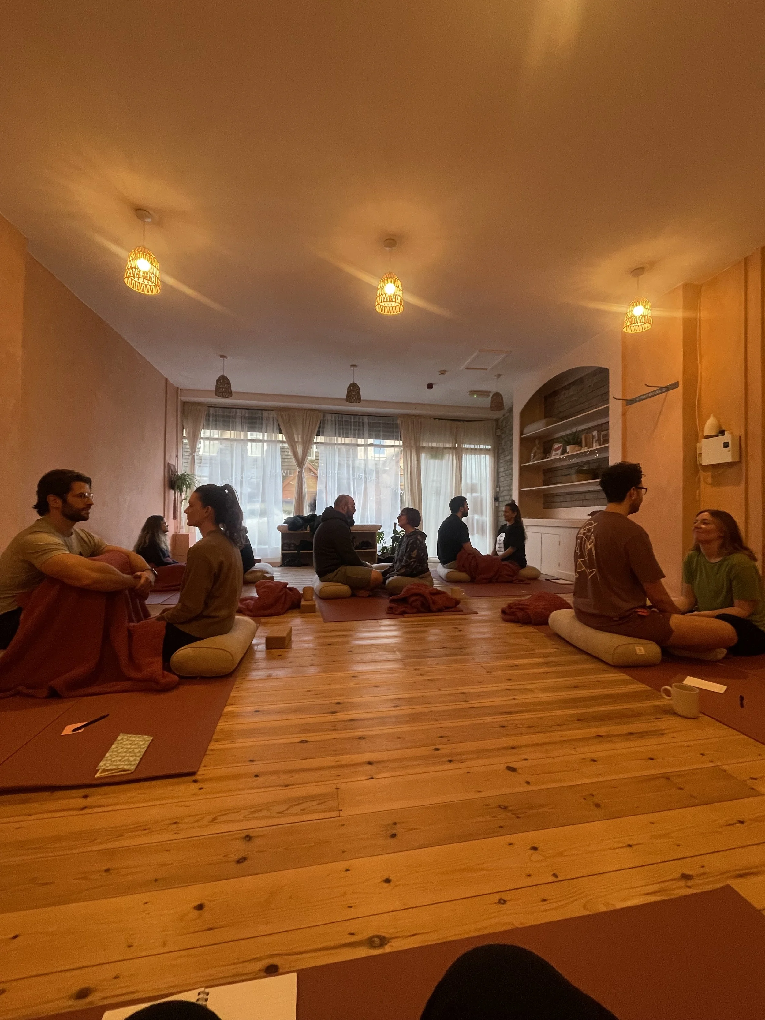 Adult couples seated in a circle in a cozy yoga studio during a sexology workshop on intimacy in Brisbane