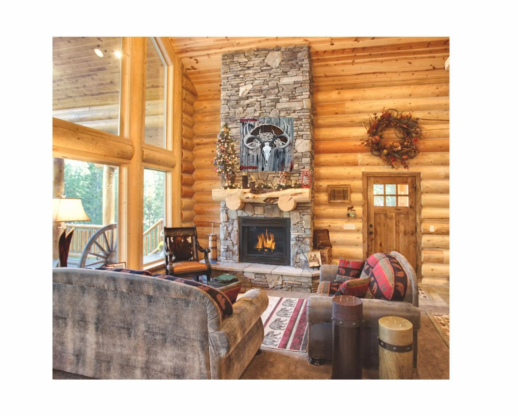 The deer skull and turkey tail painting hanging above a stone fireplace in a rustic log cabin living room.