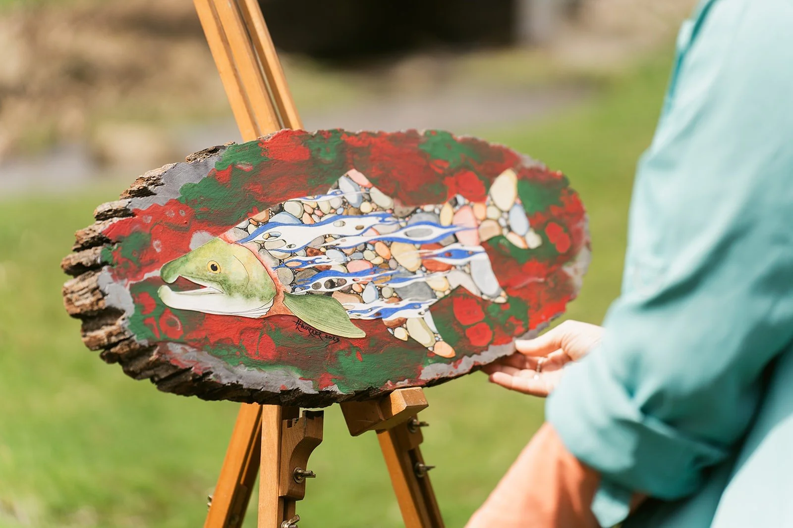 Mixed media fish painting by HL Wirtner displayed on a wood slab, featuring trout-inspired artwork rooted in water, nature, and conservation.