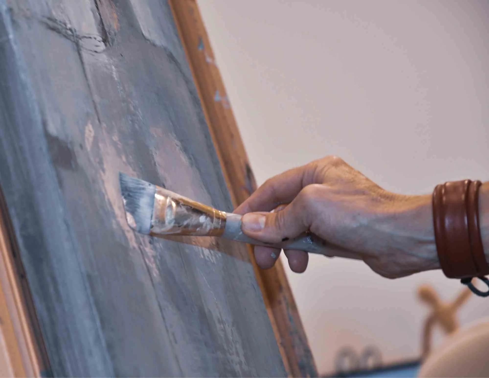Artist working on a painting in the studio, showing the creative process behind the work