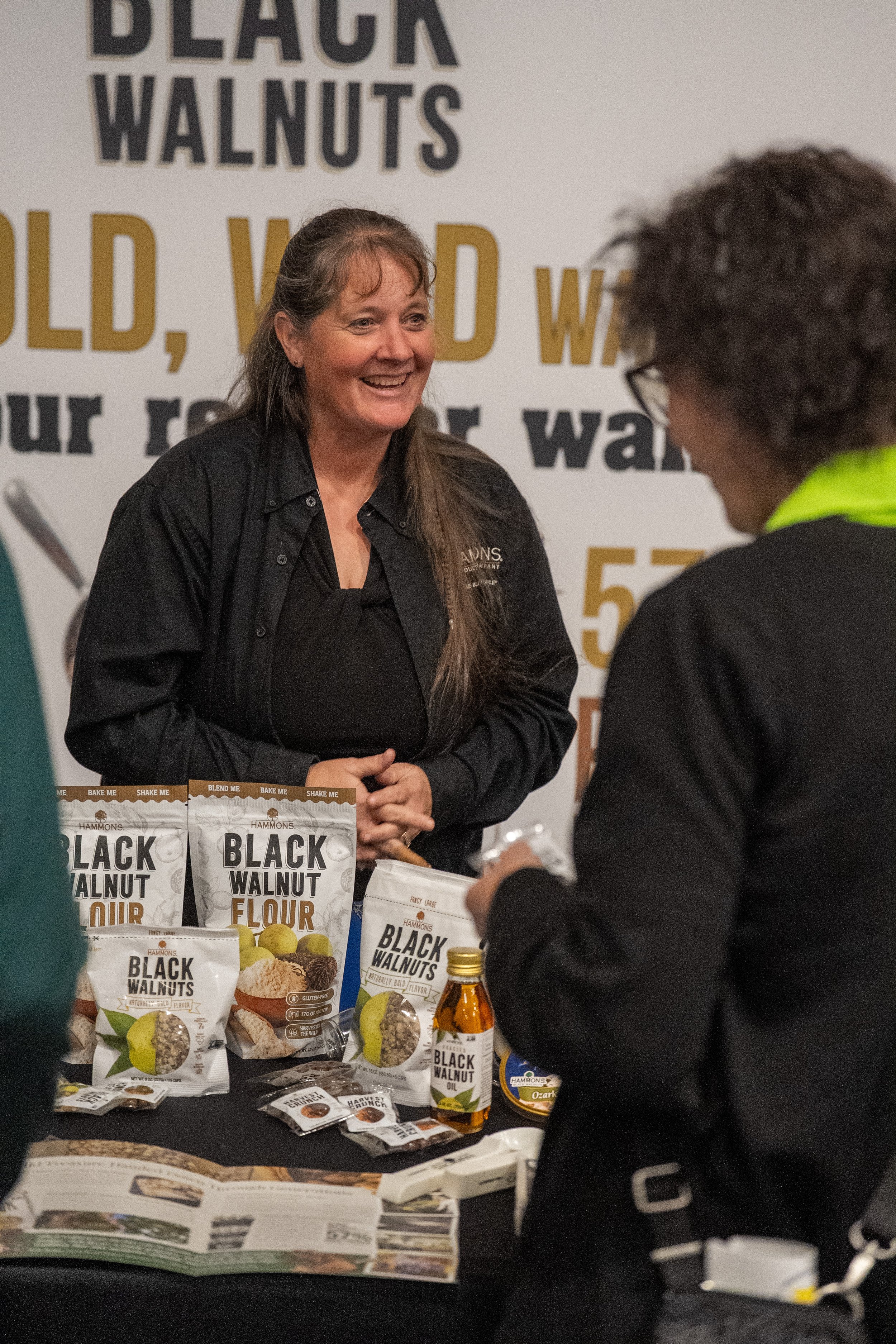 Woman showcasing black walnuts at trade show