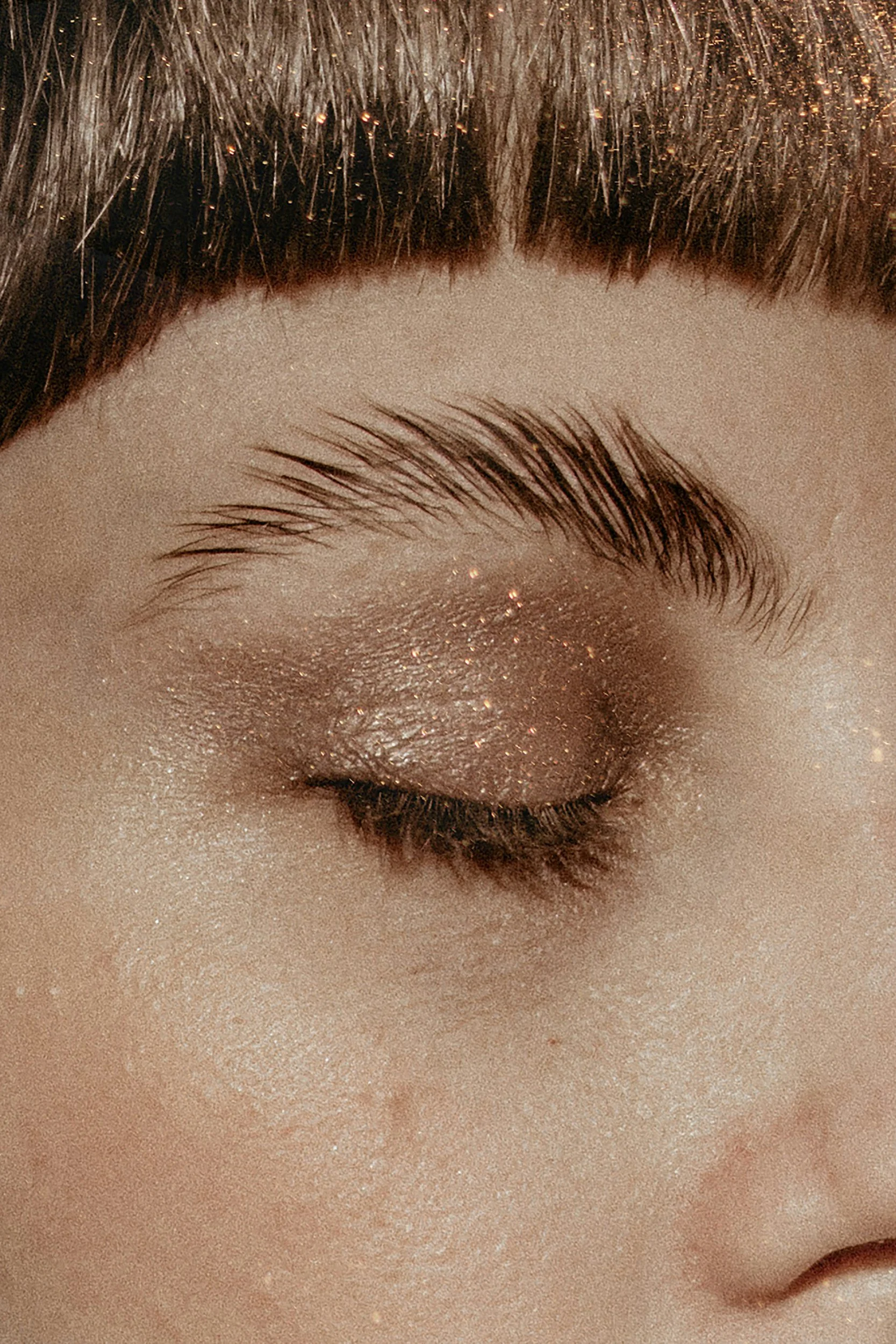 Close up of woman eye and eyebrows with glittle all over her face