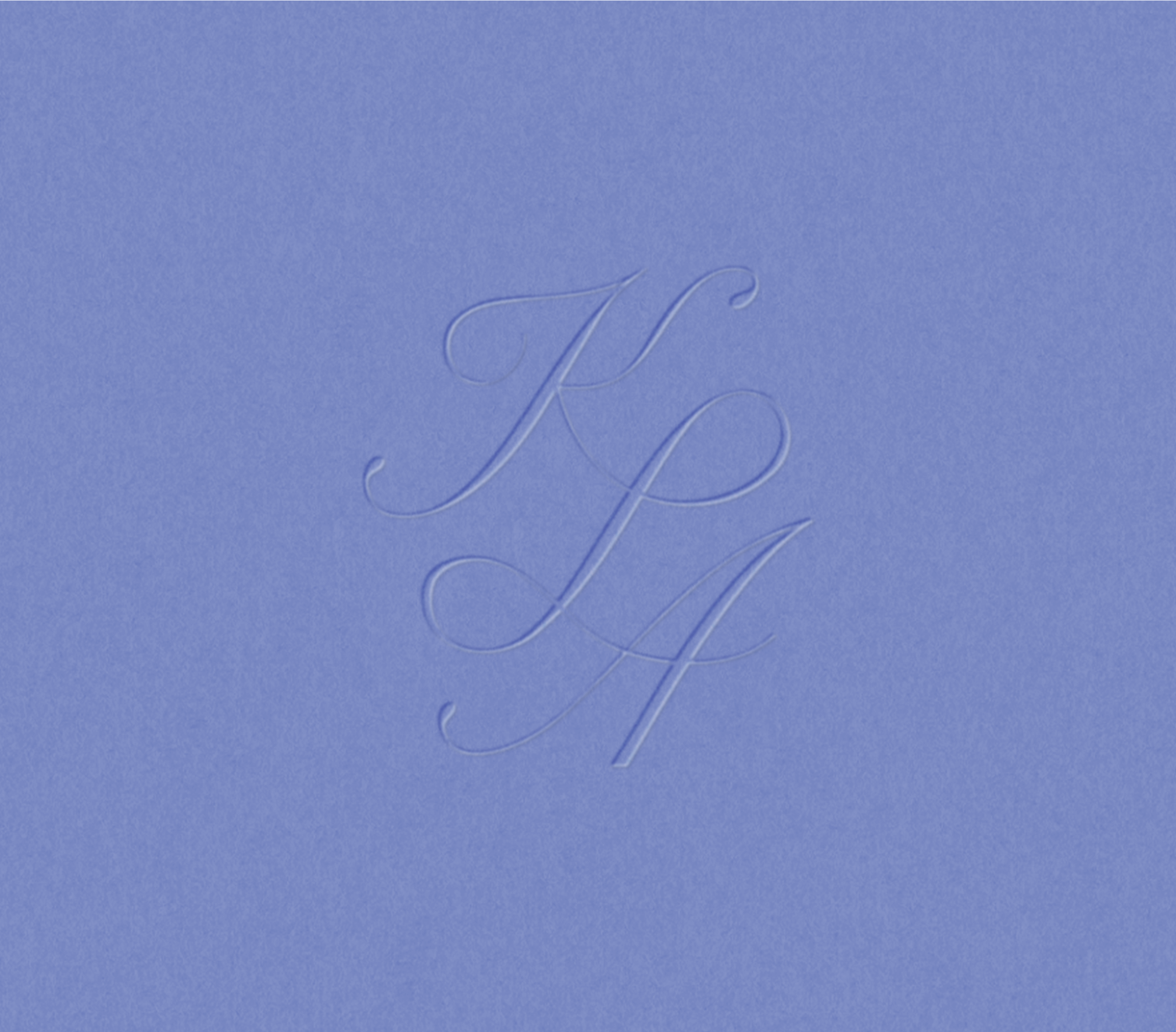 Close-up image of embossed cursive lettering on a light blue textured surface.