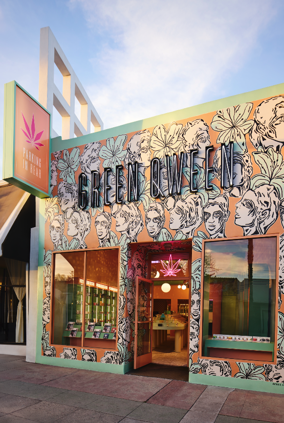 Exterior of a retail shop called 'Green Queen,' decorated with black and white illustrations of women's faces and green leaves, featuring a sign with a pink cannabis leaf and the words 'Parking in Rear,' and large display windows.