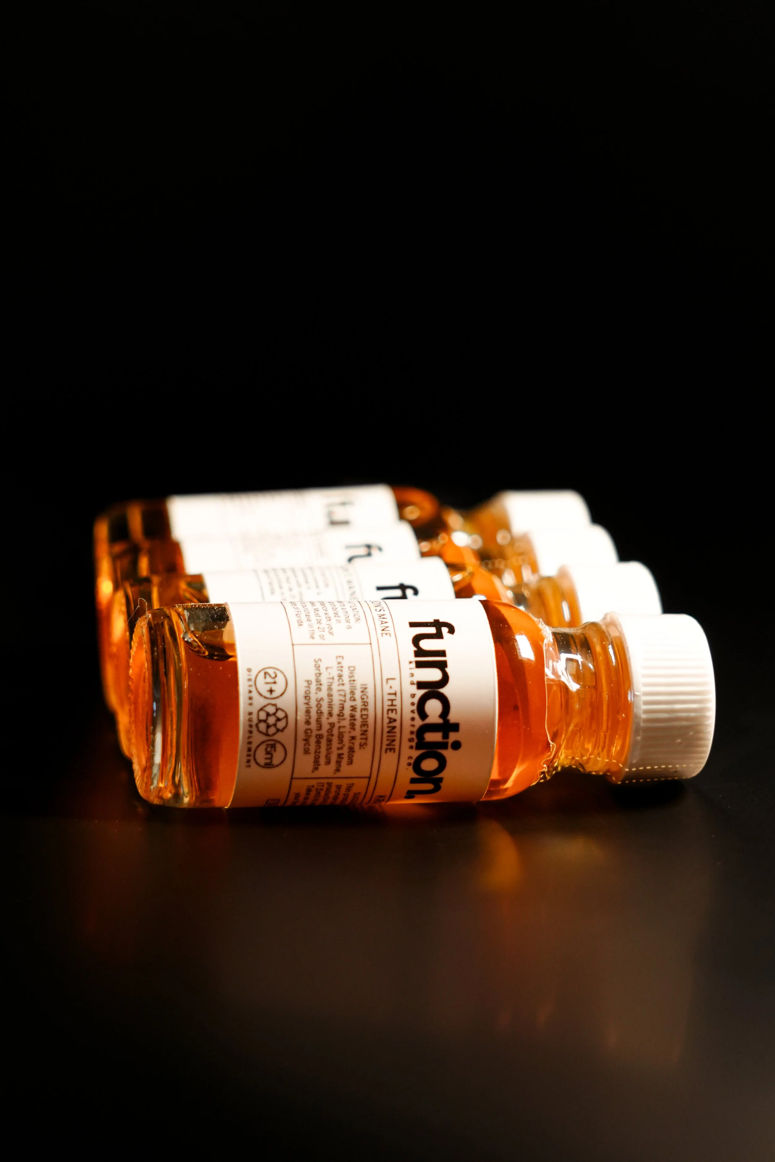 Multiple bottles of medication labeled 'Funtionson' with white caps, lying on a dark surface against a black background.