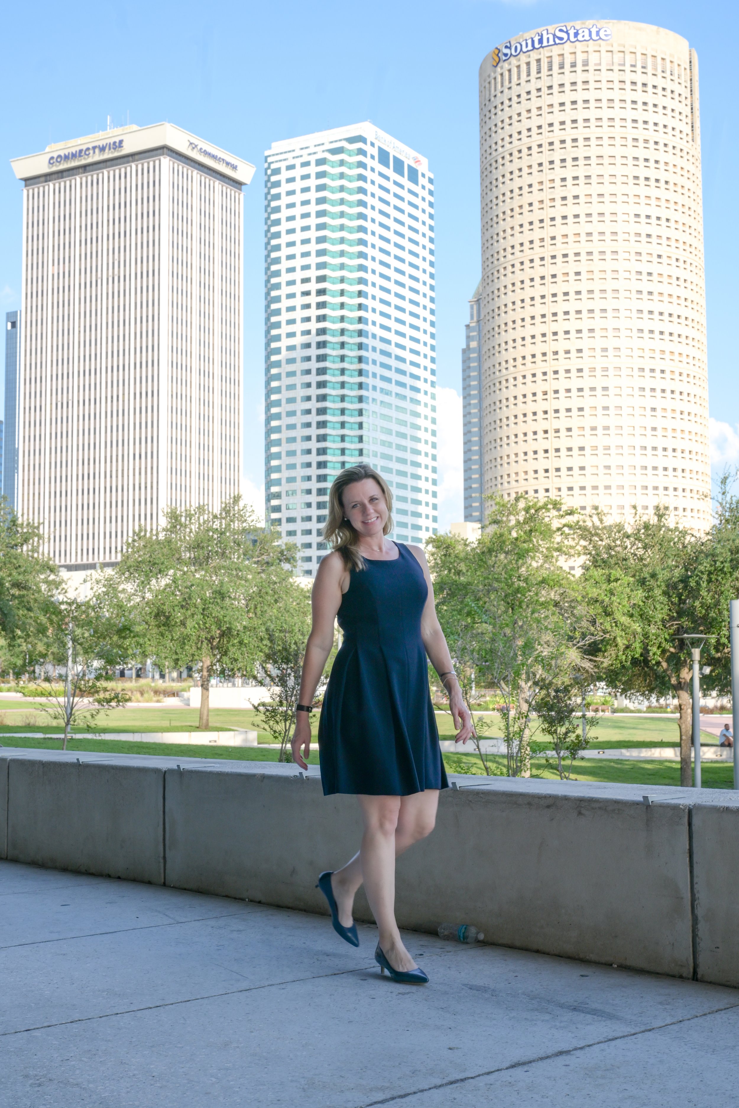 This photo shows Dr. Rebekah Hellier smiling and walking outside her office in downtown Tampa, Florida.