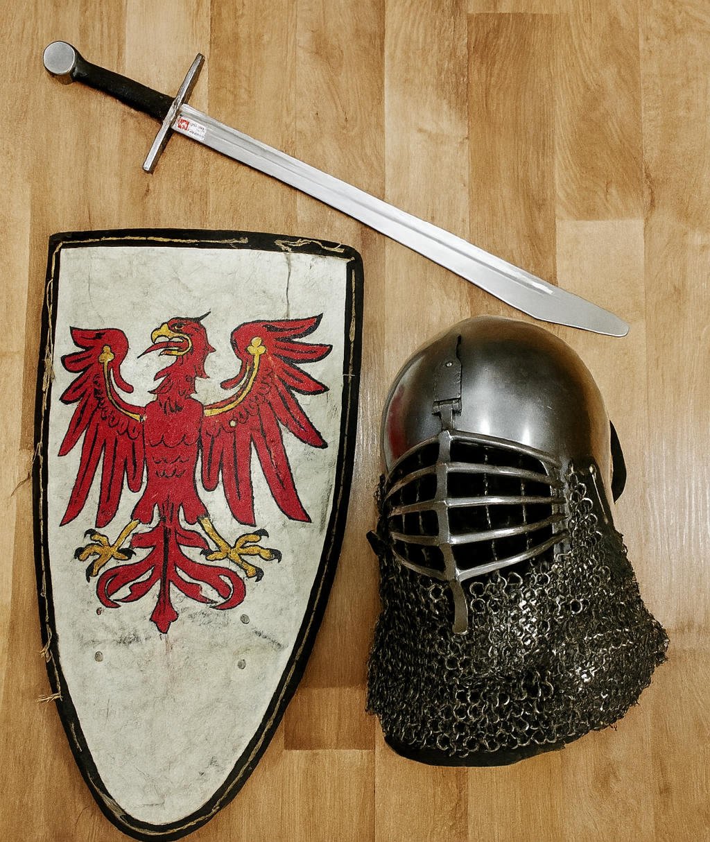 Medieval armor, sword, and a shield with a red eagle emblem on a wooden floor.