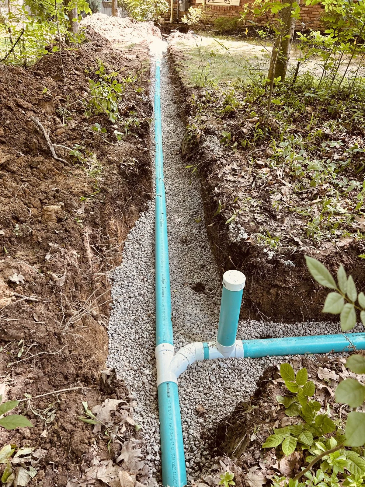 New PVC sewer line with a cleanout tee in a residential yard trench