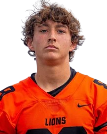 Young man with curly hair wearing an orange football jersey with black accents and the word 'LIONS' on the front, against a plain background.
