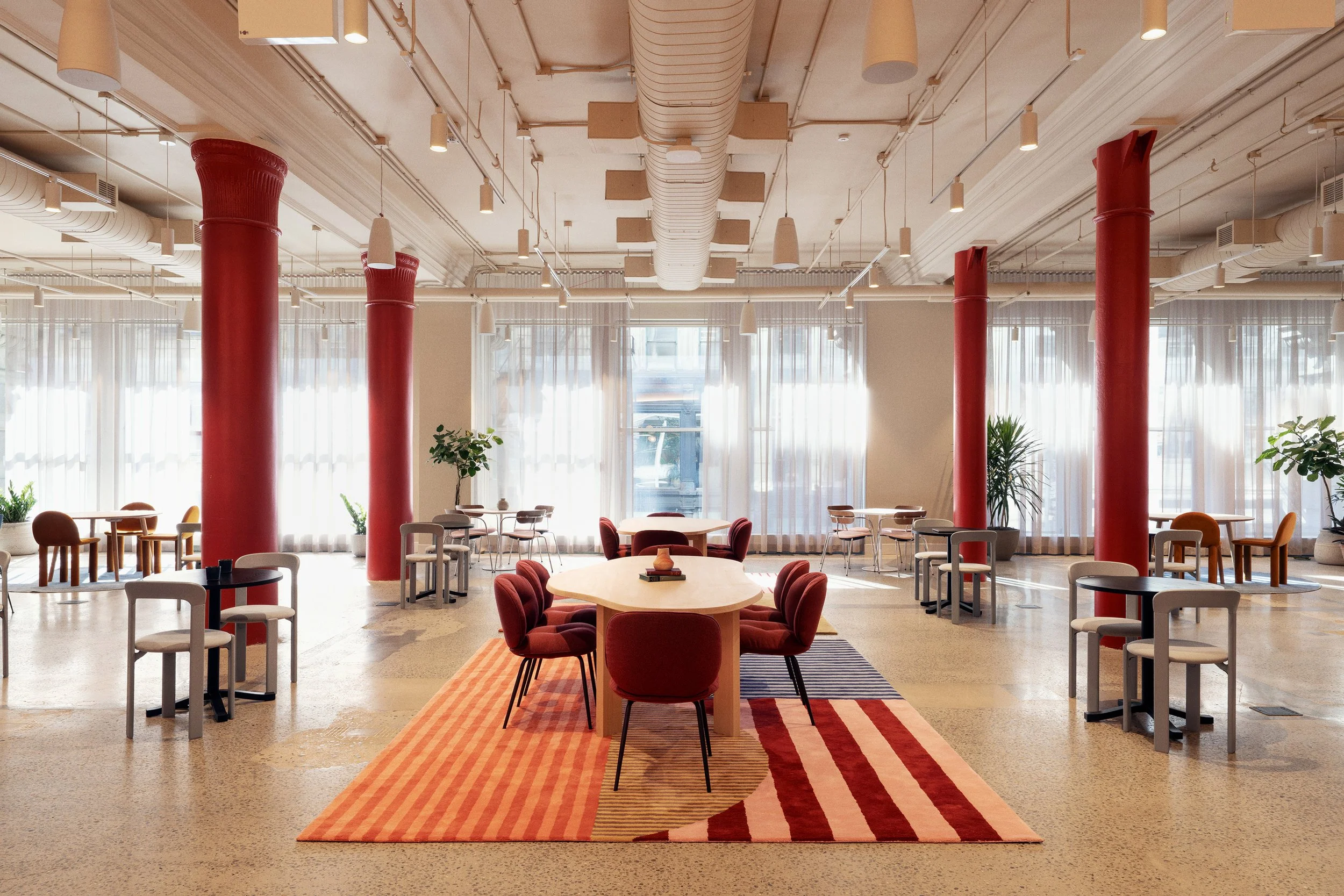 Café Seating area featuring red cast-iron columns and large arched windows, Scholastic Building SoHo NYC