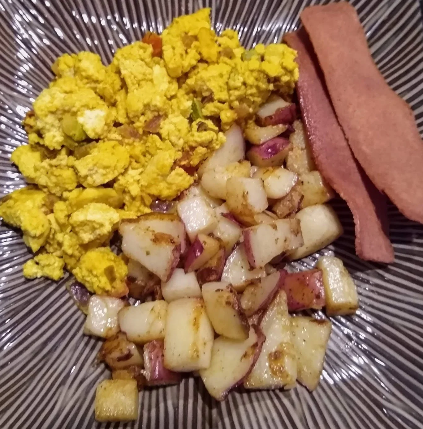 Vegan "eggs", potatoes, and plant-based "bacon
