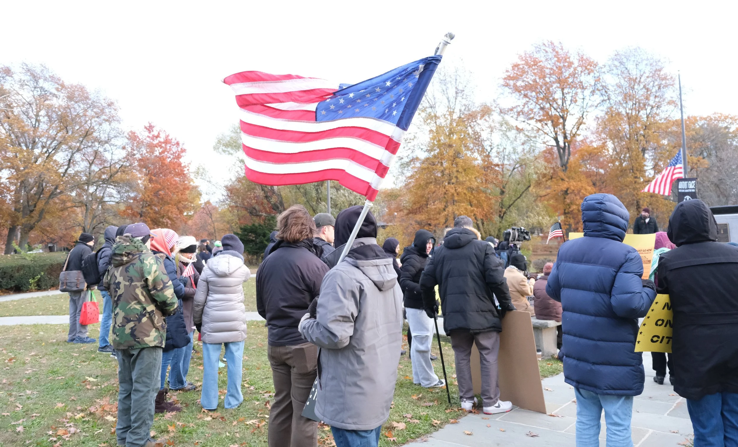 Protester holds American flag at Veterans Against ICE rally (BU Daily Free Press, Nov. 2025)