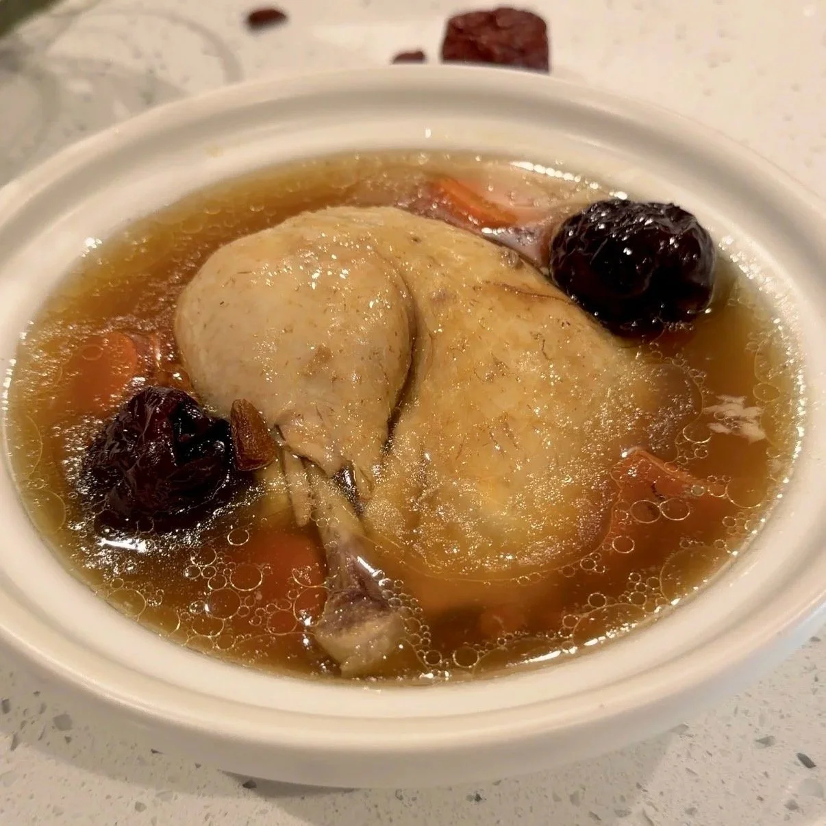 Easy Instantpot Chinese herbal chicken soup without seasoning, salt free, with red dates, carrots, goji berries, pasture raised chicken. Hormone friendly. Chicken soup in a beige claypot. No added salt, sugar or oil.