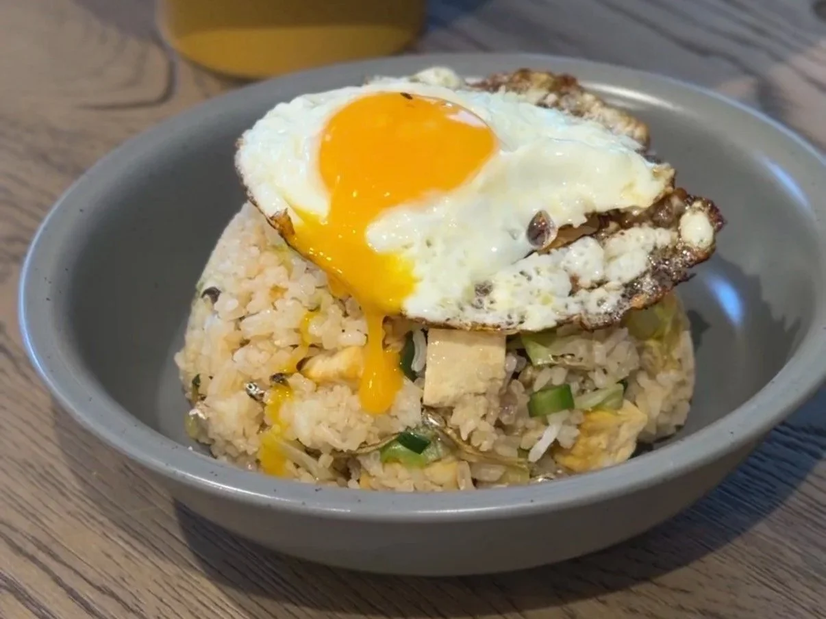 Easy fried rice with green beans, cabbage, anchovies, tofu, topped with fried eggs, used leftover takeout rice from Chinese takeout. Served in a grey aesthetic earthy tone plate bowl.