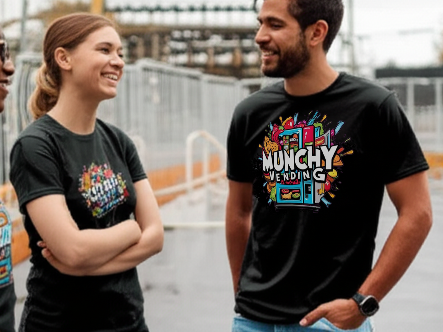 Three people engaging in a conversation outdoors, two women and one man, all wearing black shirts with the "Munchy Vending" logo, smiling and appearing friendly.