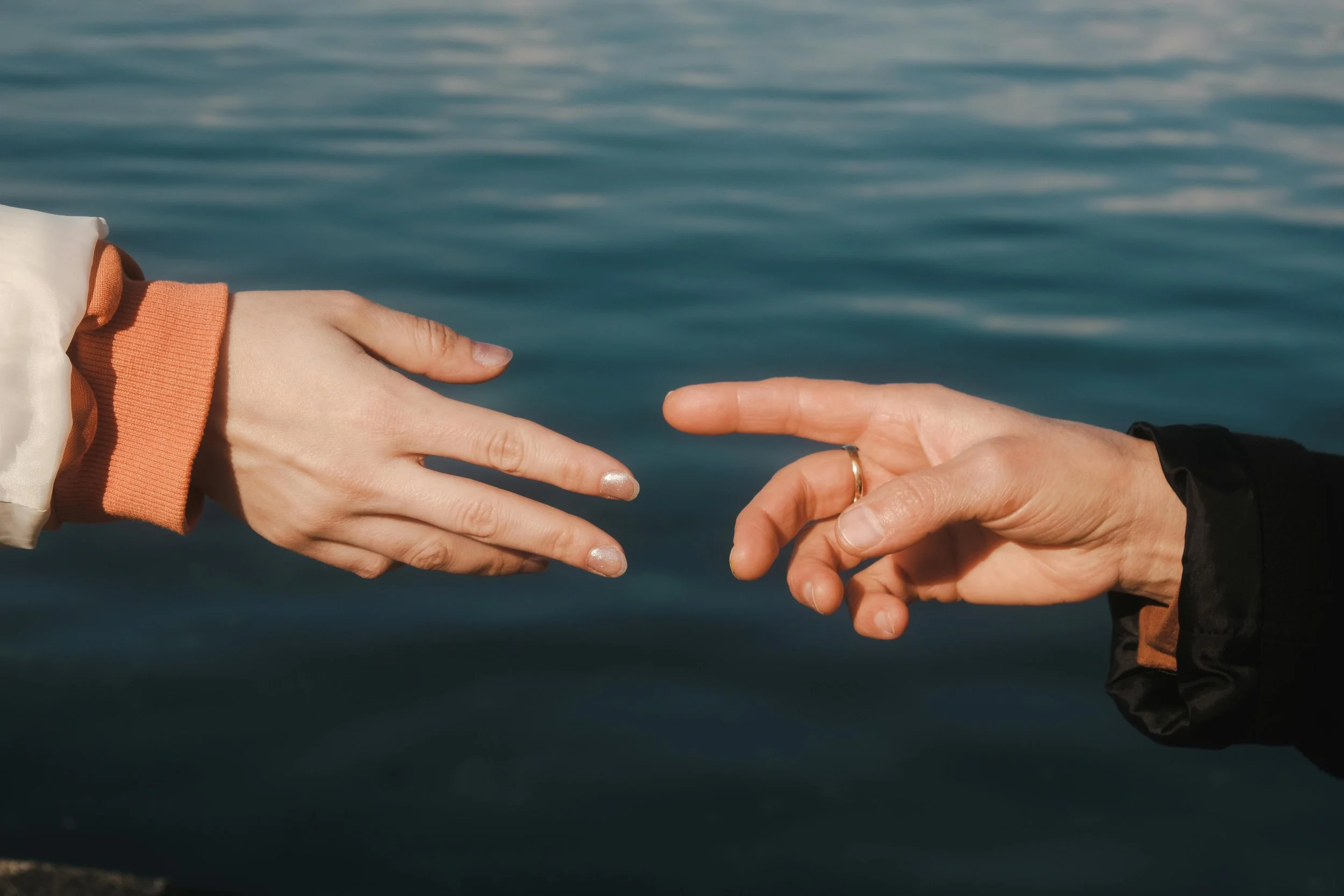 Two hands reaching toward each other representing connection and relationship support in therapy
