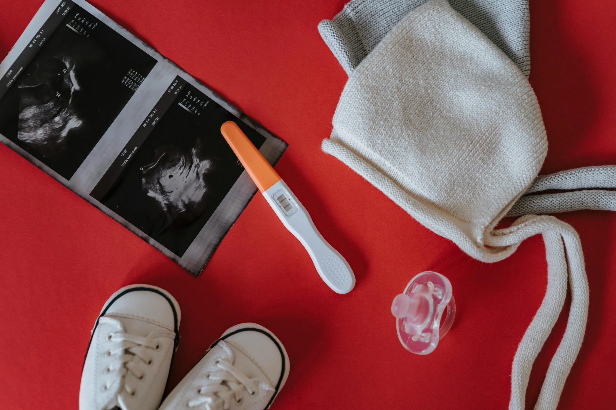 Ultrasound image and baby items representing pregnancy and the transition to parenthood