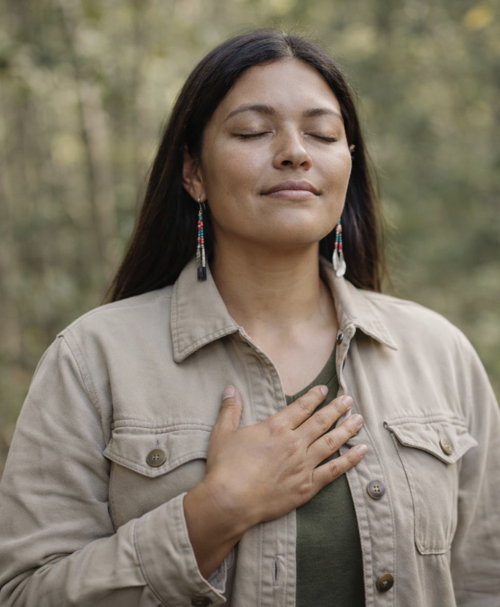 Indigenous woman practising mindful breathing outdoors, representing mindfulness-based therapy and emotional regulation services available virtually across Ontario and in Smiths Falls.