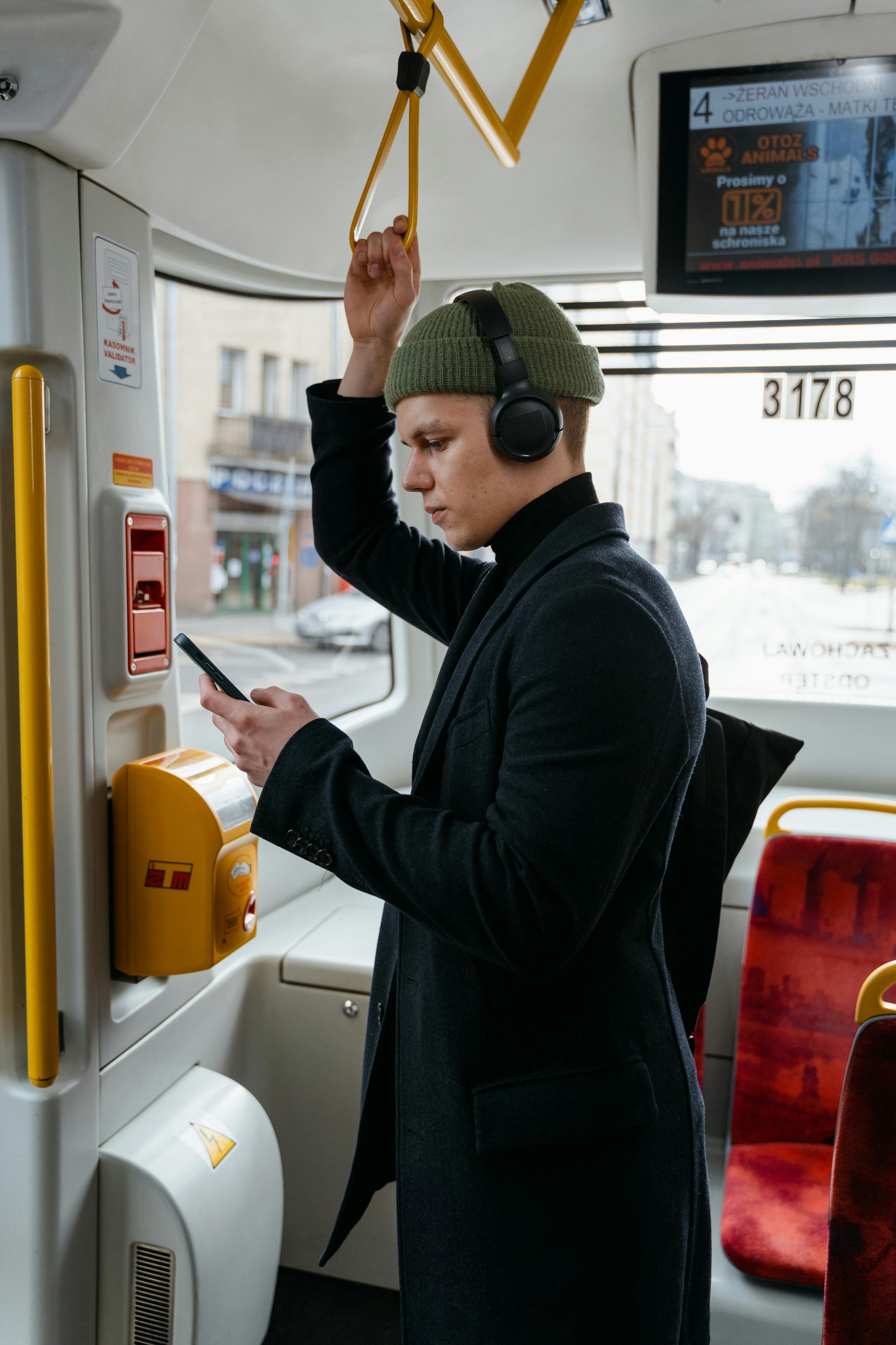 Young adult wearing headphones on public transit to manage sensory overload