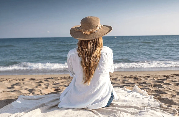 Woman relaxing by the water in June in Ontario, enjoying the sun and summer breeze.