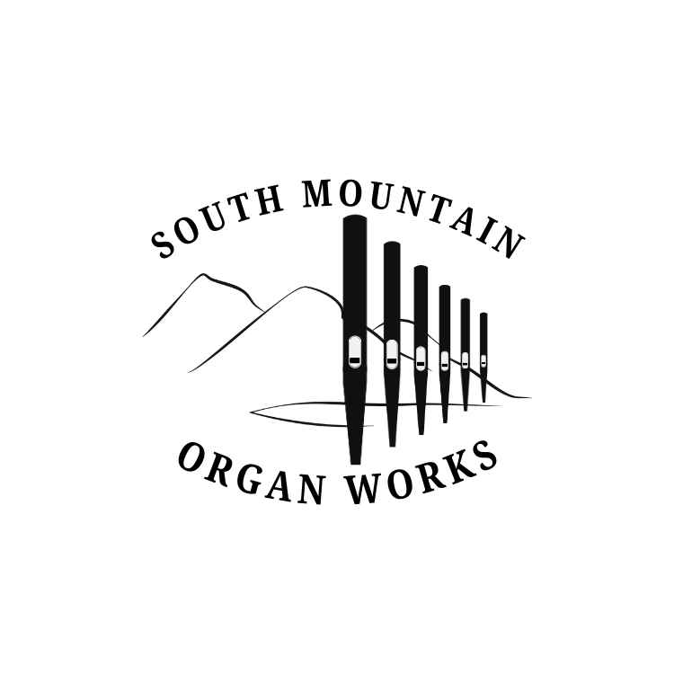 A black and white illustration of the South Mountain Organ Works logo. It uses line art to replicate the silhouette of South Mountain, a row of organ pipes, and both of these meet in the middle.
