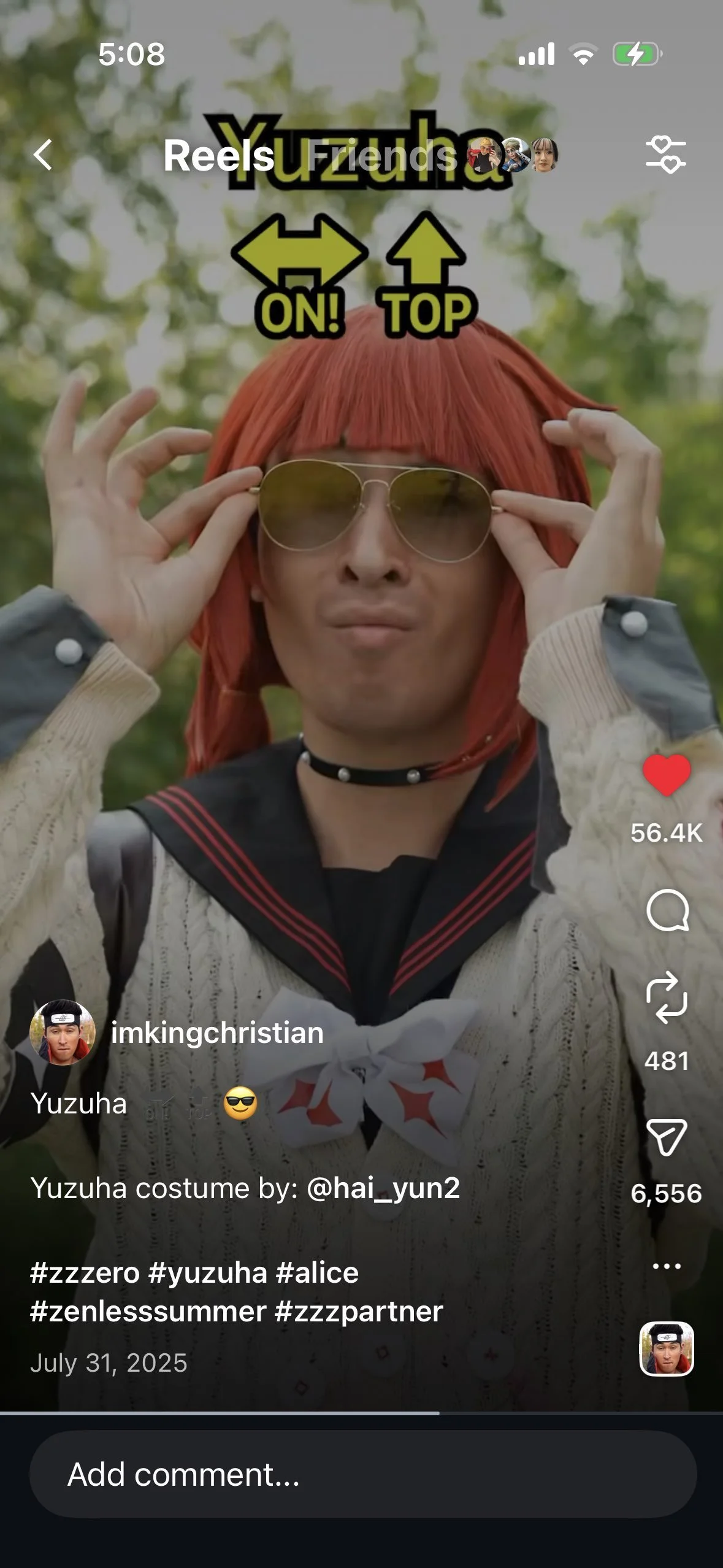 Person wearing a red wig, sunglasses, a choker, and a sailor-style costume with a bow, standing outdoors with blurred green trees in the background.