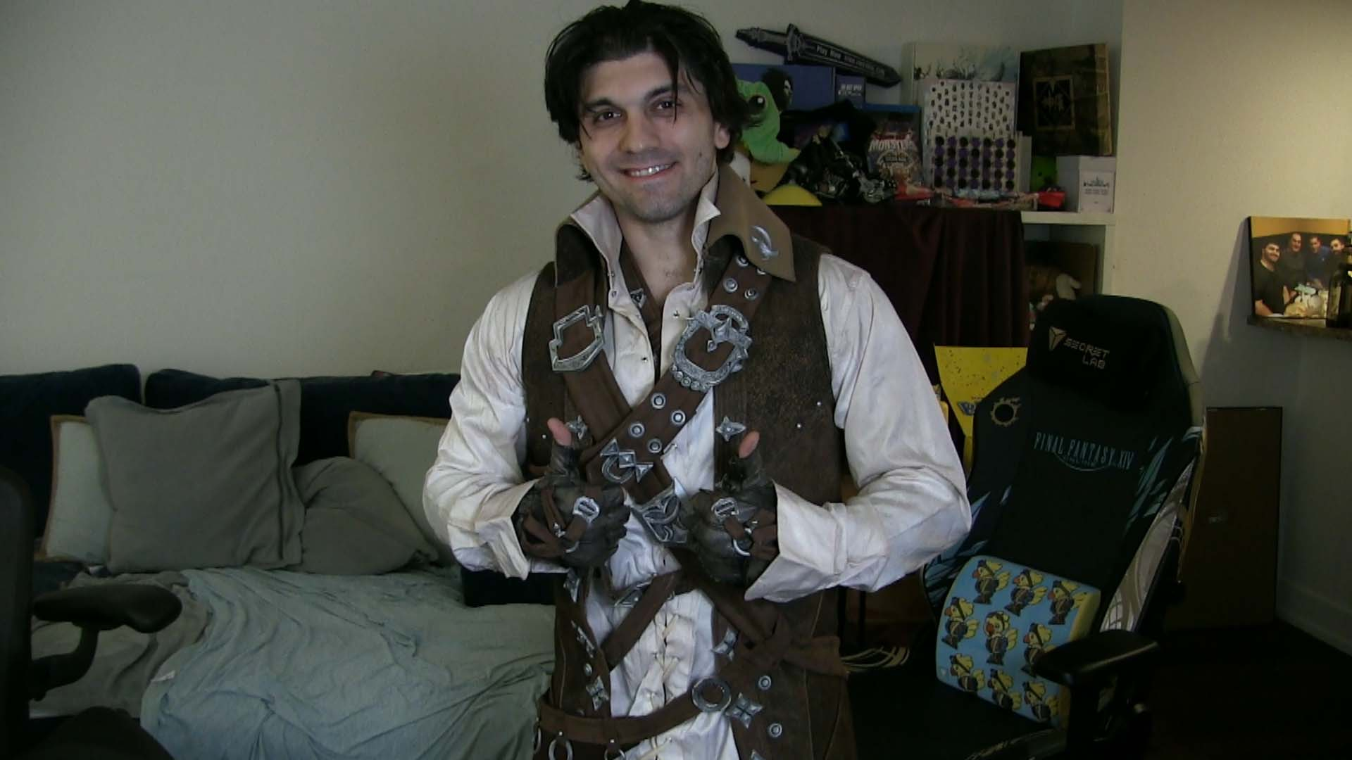 Person dressed as a fantasy or steampunk character with leather and metal accessories, making a thumbs-up gesture indoors.