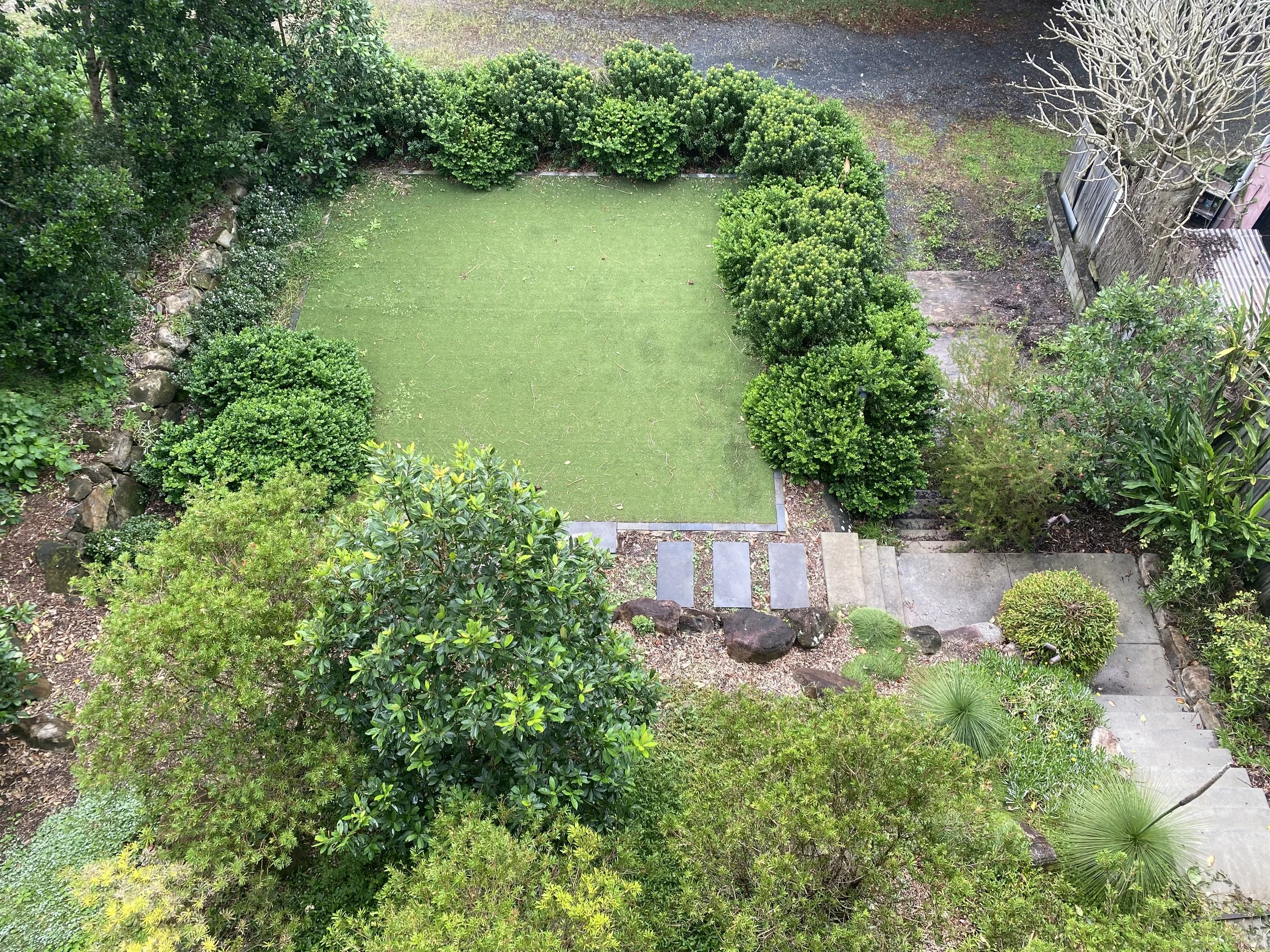 Low-maintenance landscape design in Lennox Head with ocean views, native grasses, and modern stone paving.