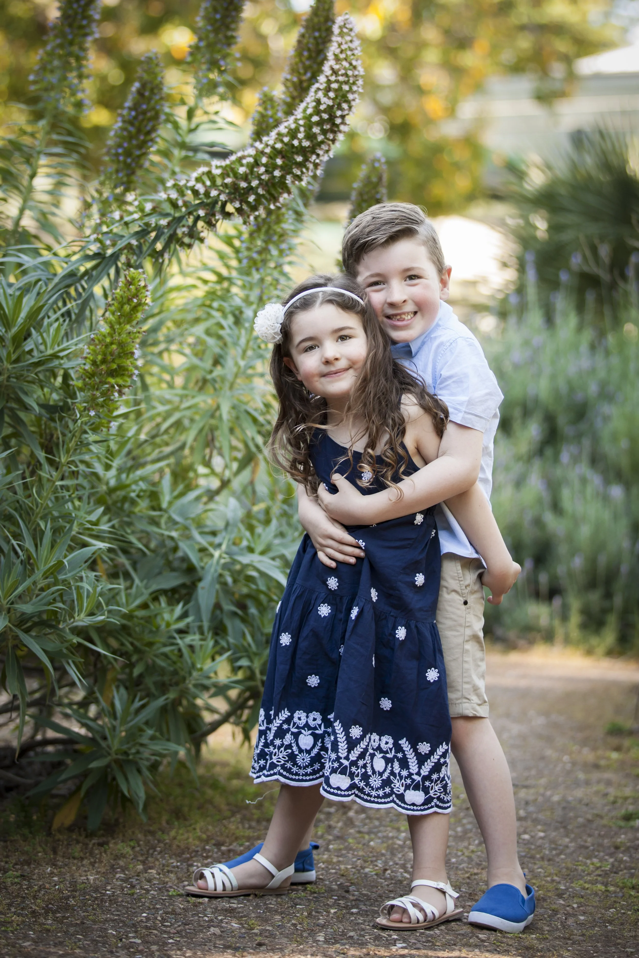 Young brother and sister posing among the gardens at Adelaide Botanic Garden