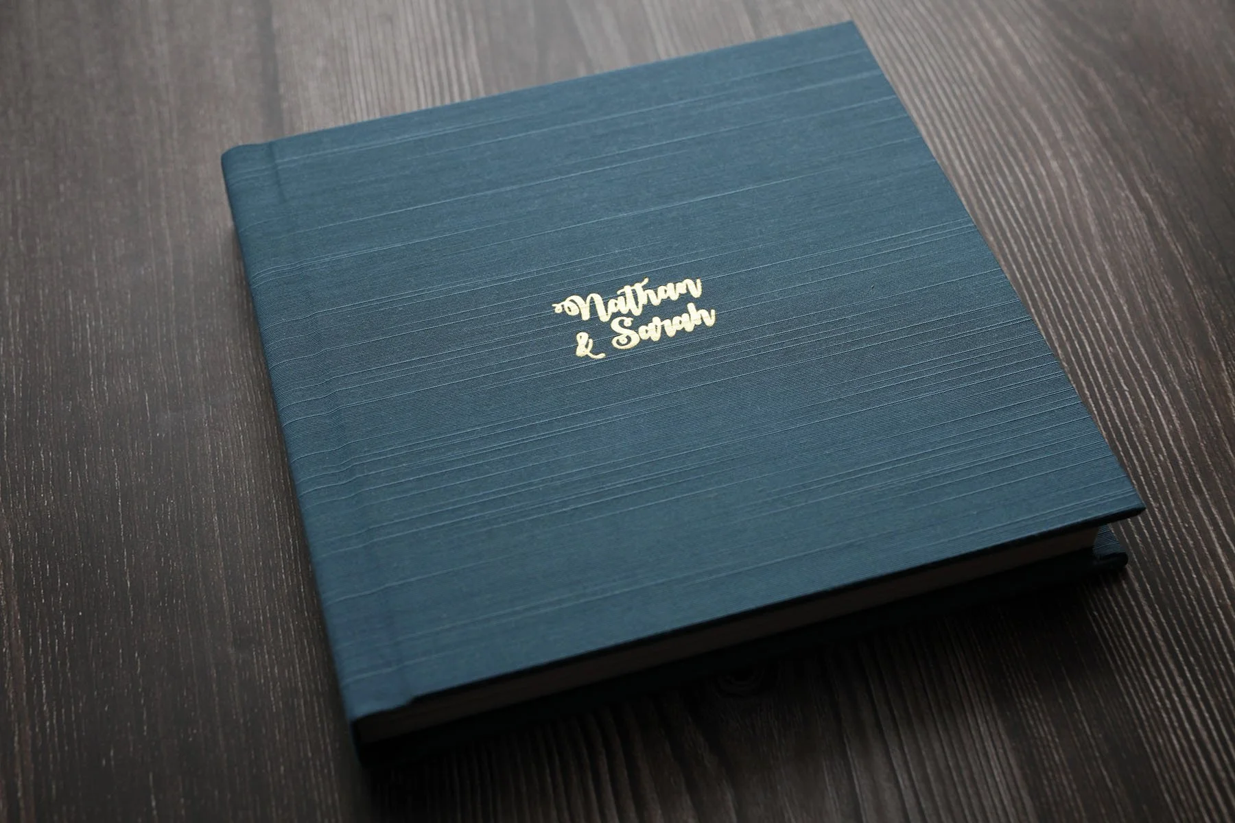 A teal-colored wedding photo album