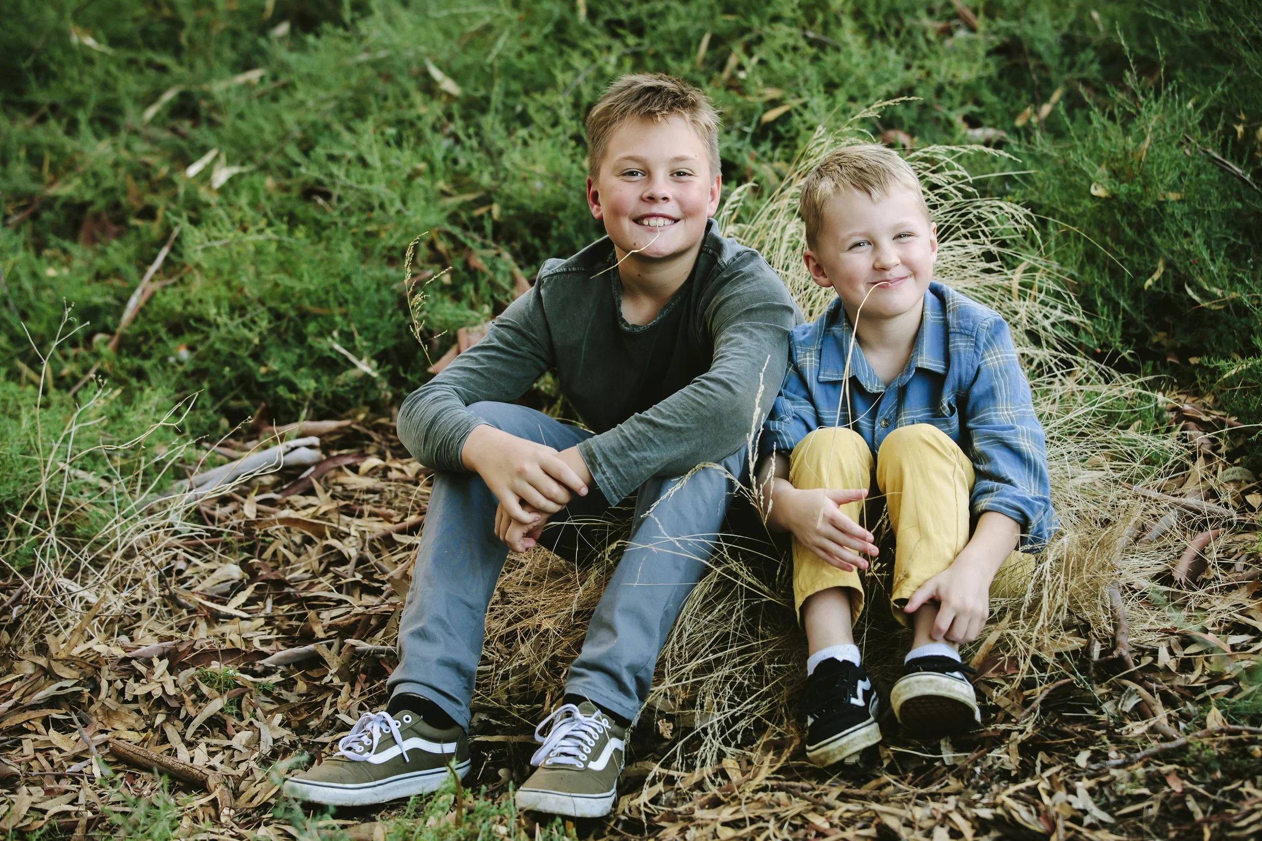 brothers-in-park-with-hay-in-mouth