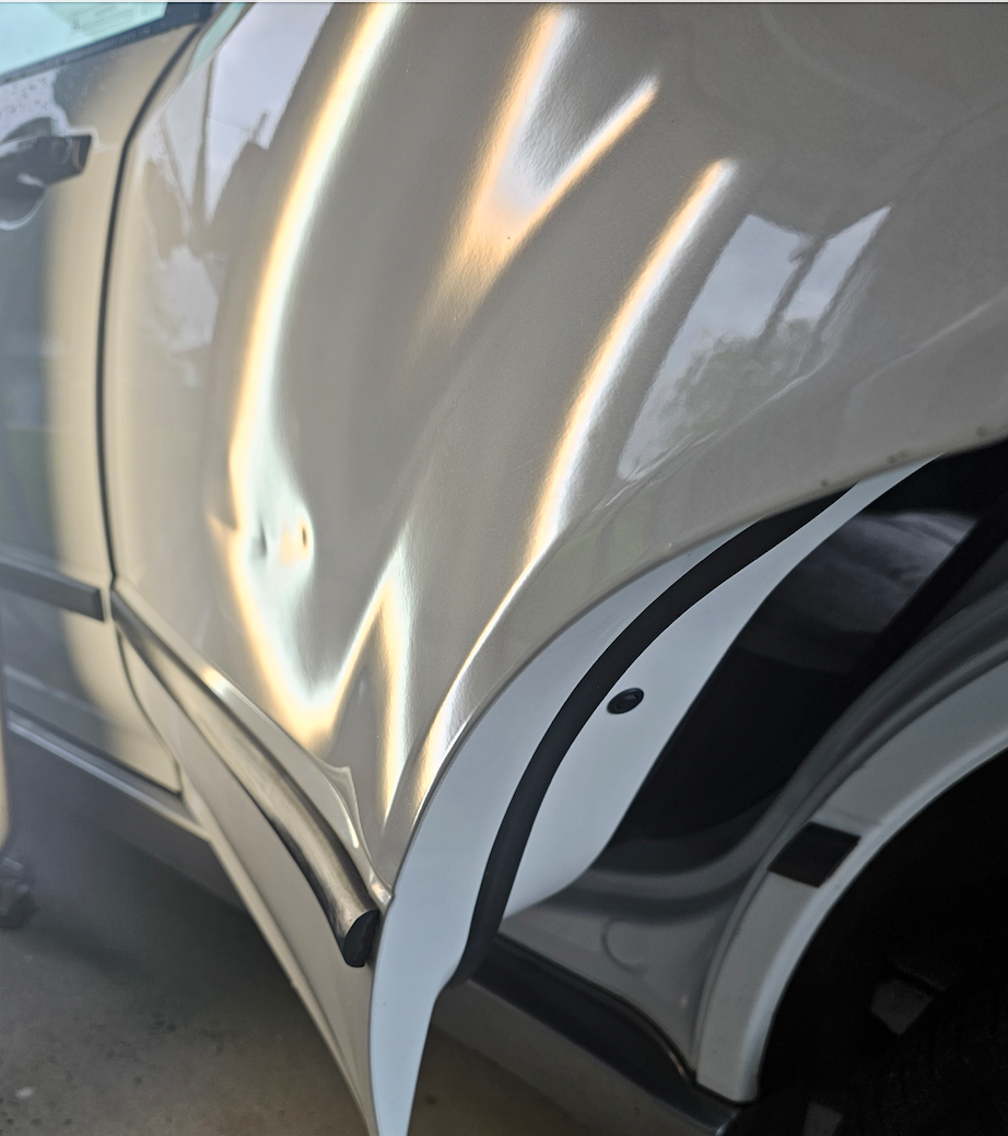 Before — Large door dent shown under a PDR inspection light.